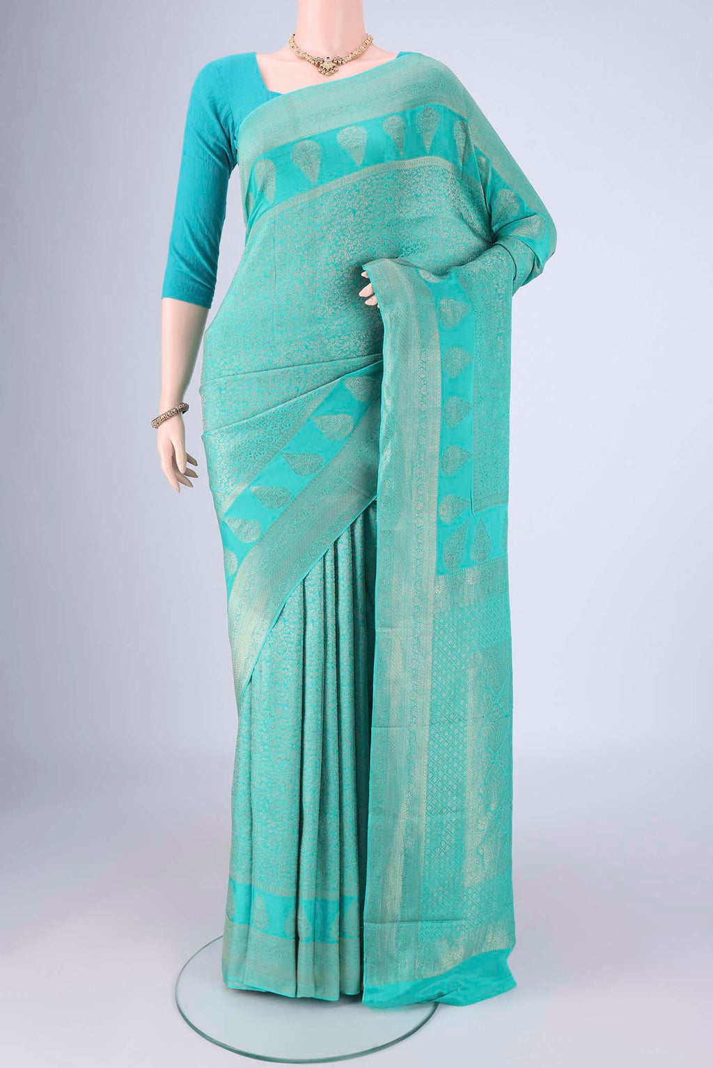Turquoise Mysore Crepe Saree with Zari Brocade on the body and Zari Border.  displayed on a mannequin