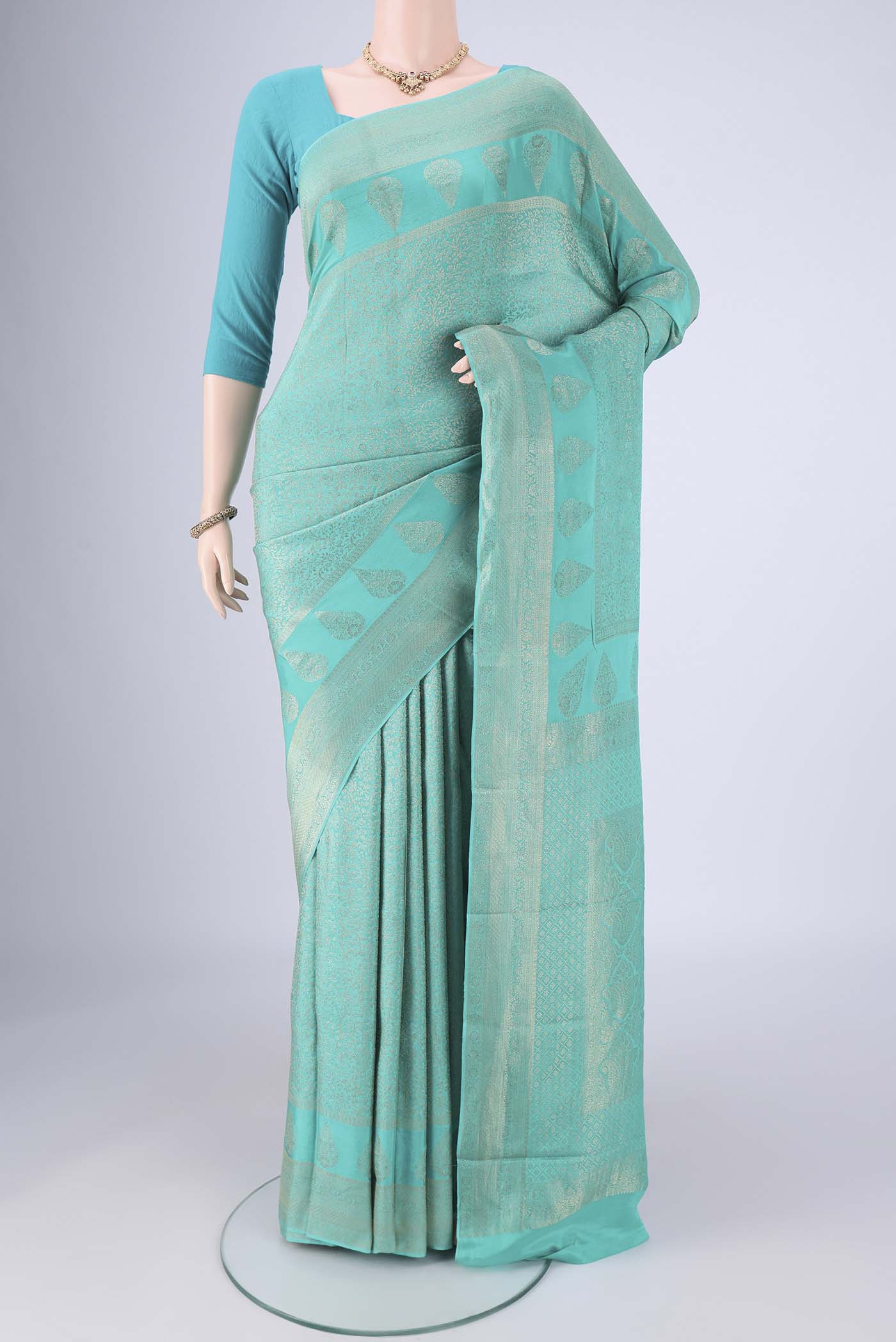 Turquoise Mysore Crepe Saree with Zari Brocade on the body and Zari Border.  displayed on a mannequin
