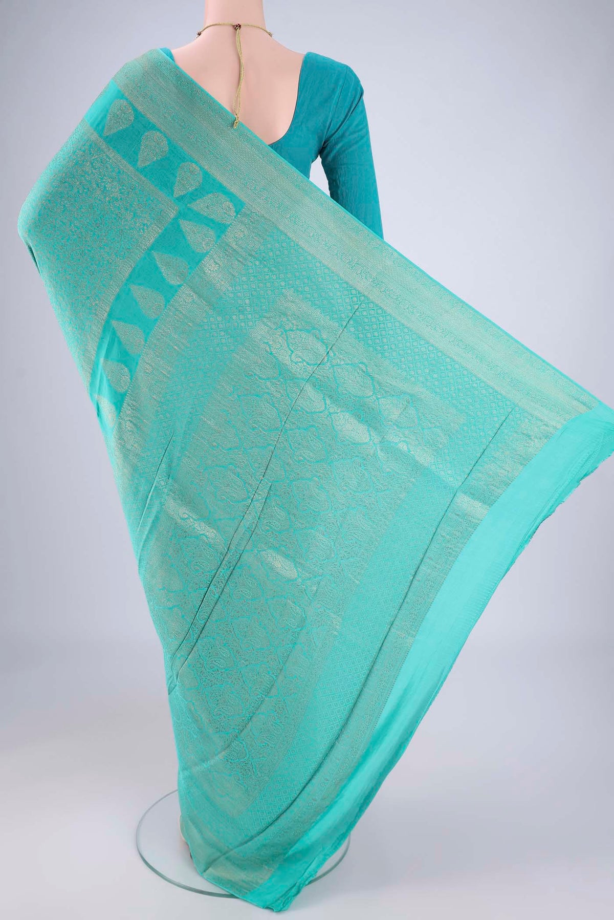 Flat view of Turquoise Mysore Crepe Saree with Zari Brocade on the body and Zari Border. 