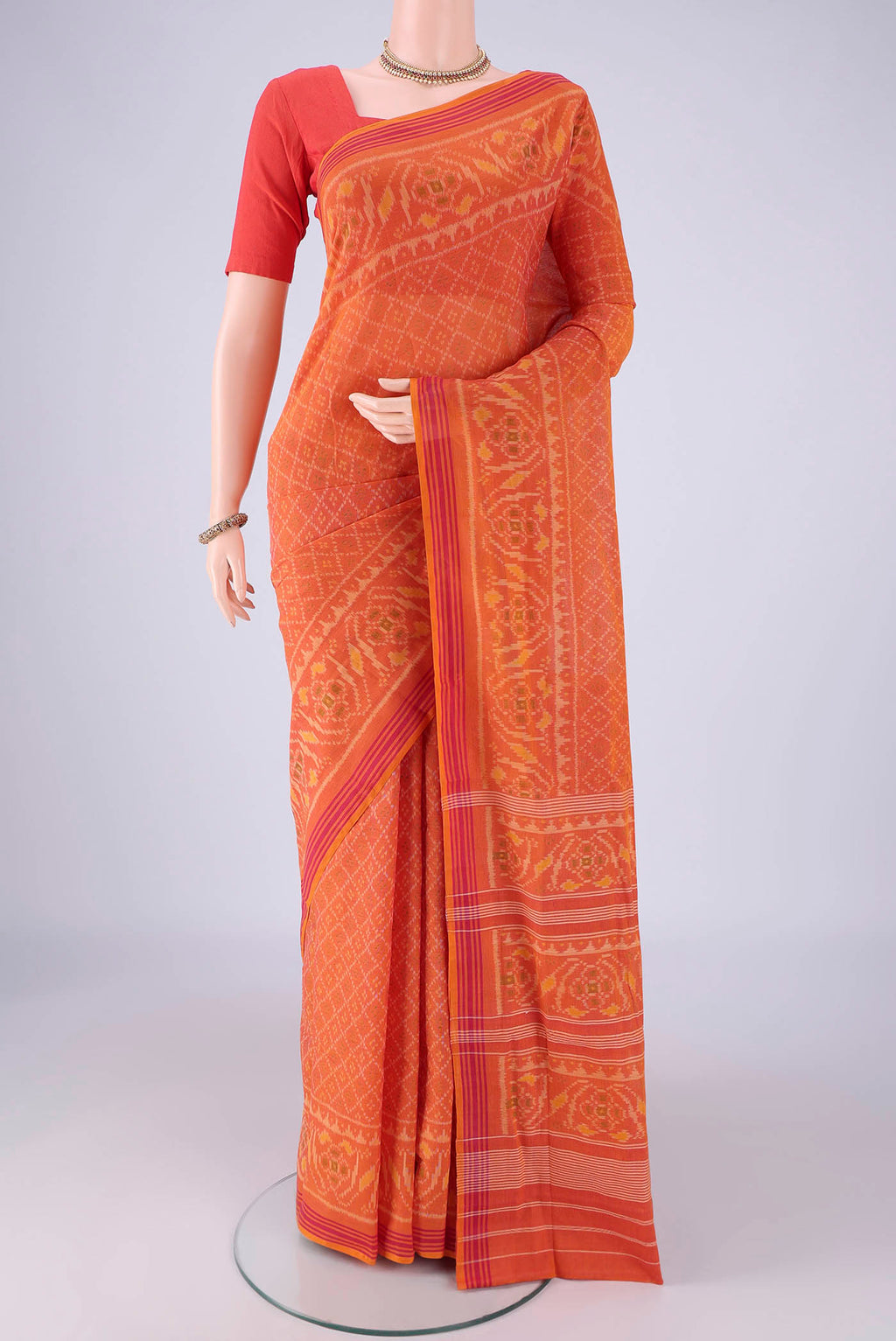 Brick Orange Pochampally Cotton Saree with Pure Ikat on the body and Ikat Border.  displayed on a mannequin