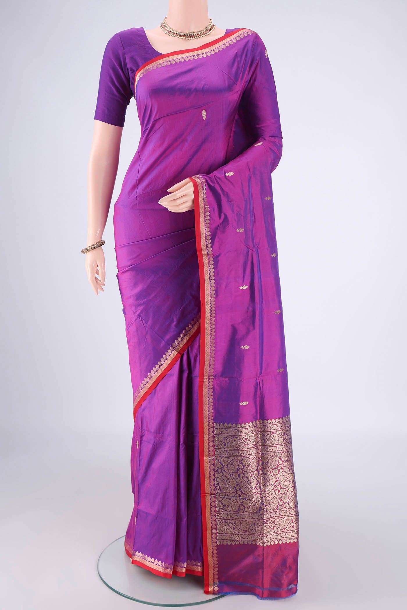 Magenta Banarasi Katan Silk Saree with Zari Butta on the body and Zari Border.  displayed on a mannequin