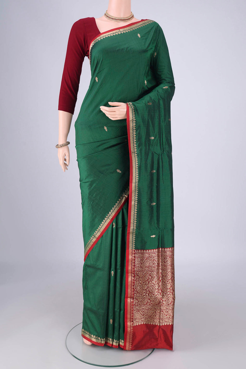 Bottle Green Banarasi Katan Silk Saree with Zari Butta on the body and Zari Border.  displayed on a mannequin