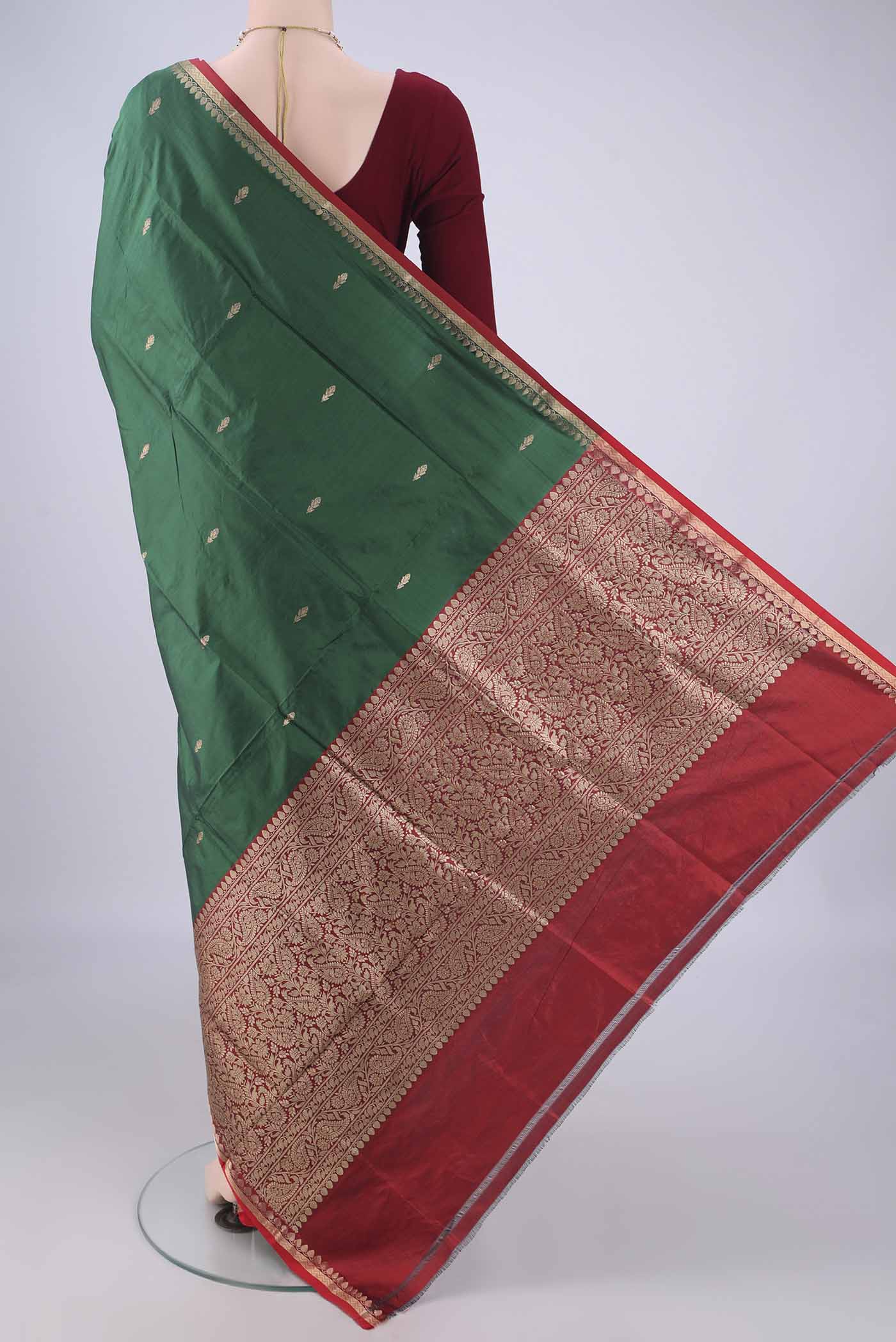 Flat view of Bottle Green Banarasi Katan Silk Saree with Zari Butta on the body and Zari Border. 