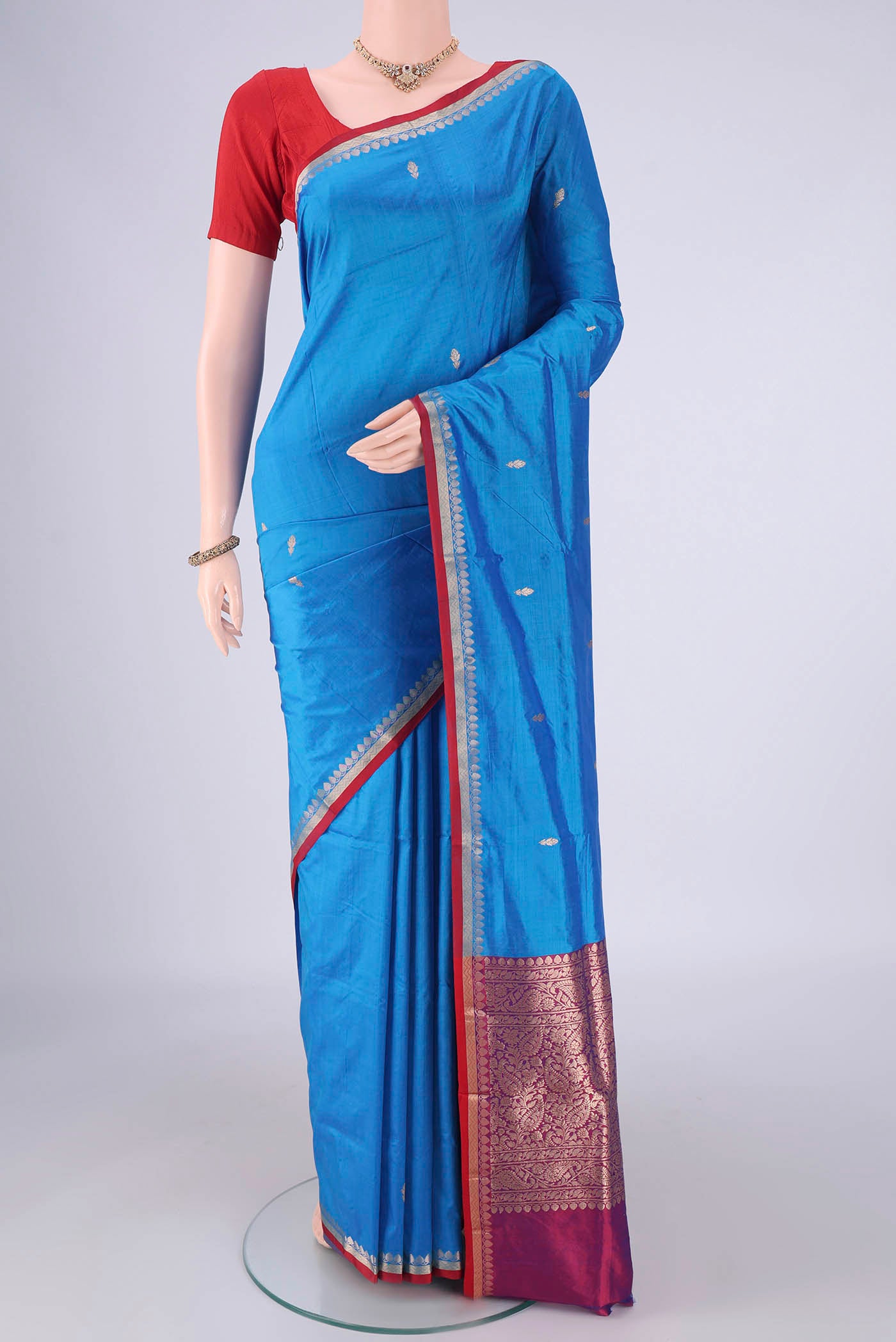 Blue Banarasi Katan Silk Saree with Zari Butta on the body and Zari Border.  displayed on a mannequin