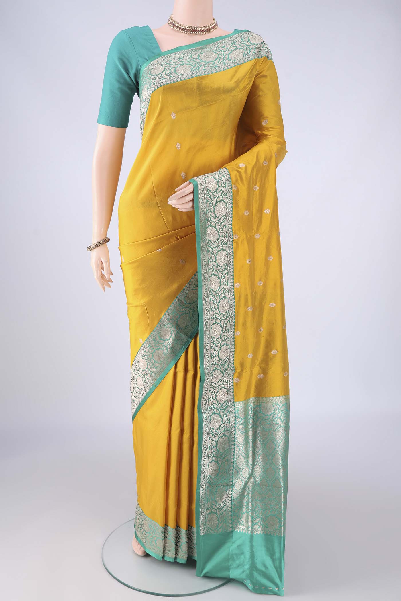 Yellow Banarasi Katan Silk Saree with Zari Butta on the body and Zari Border.  displayed on a mannequin