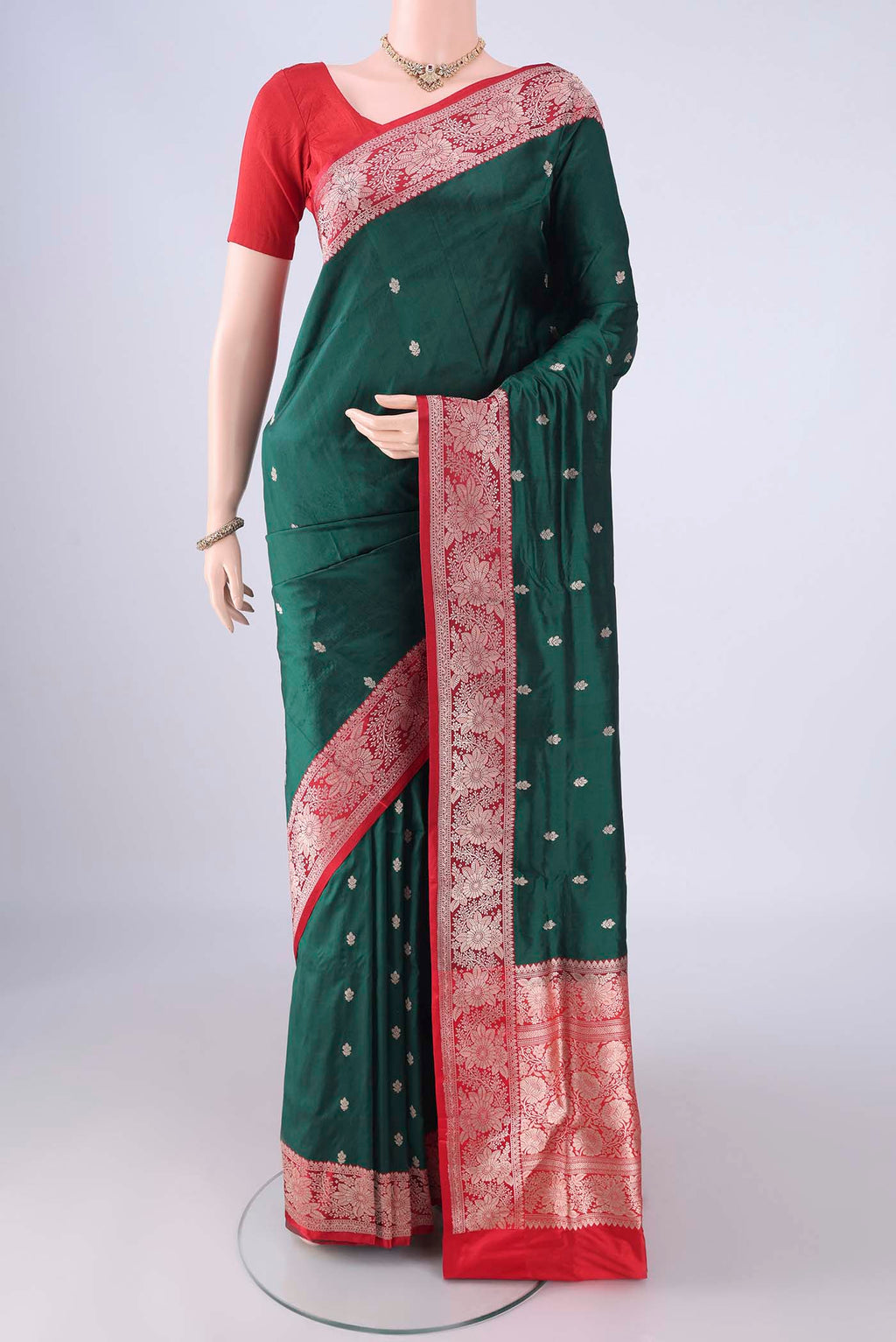 Bottle Green Banarasi Katan Silk Saree with Zari Butta on the body and Zari Border.  displayed on a mannequin