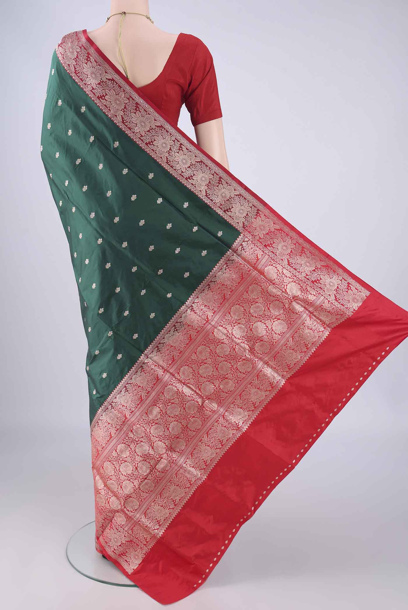 Flat view of Bottle Green Banarasi Katan Silk Saree with Zari Butta on the body and Zari Border. 