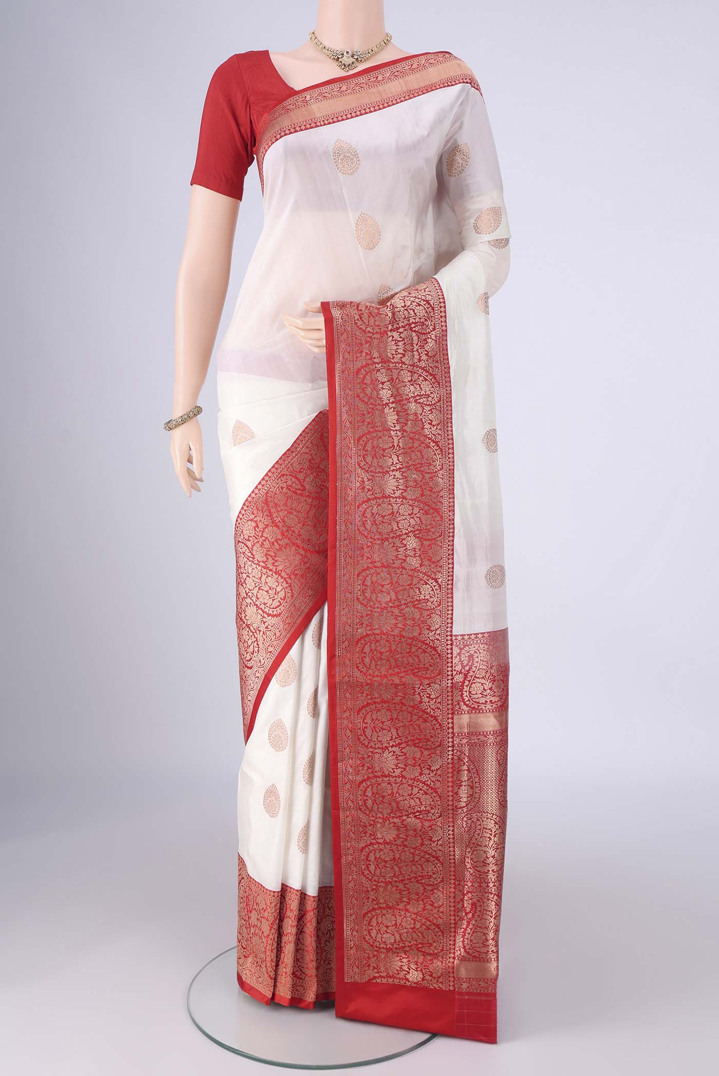 White Banarasi Silk Saree with Zari Butta on the body and Zari Border.  displayed on a mannequin