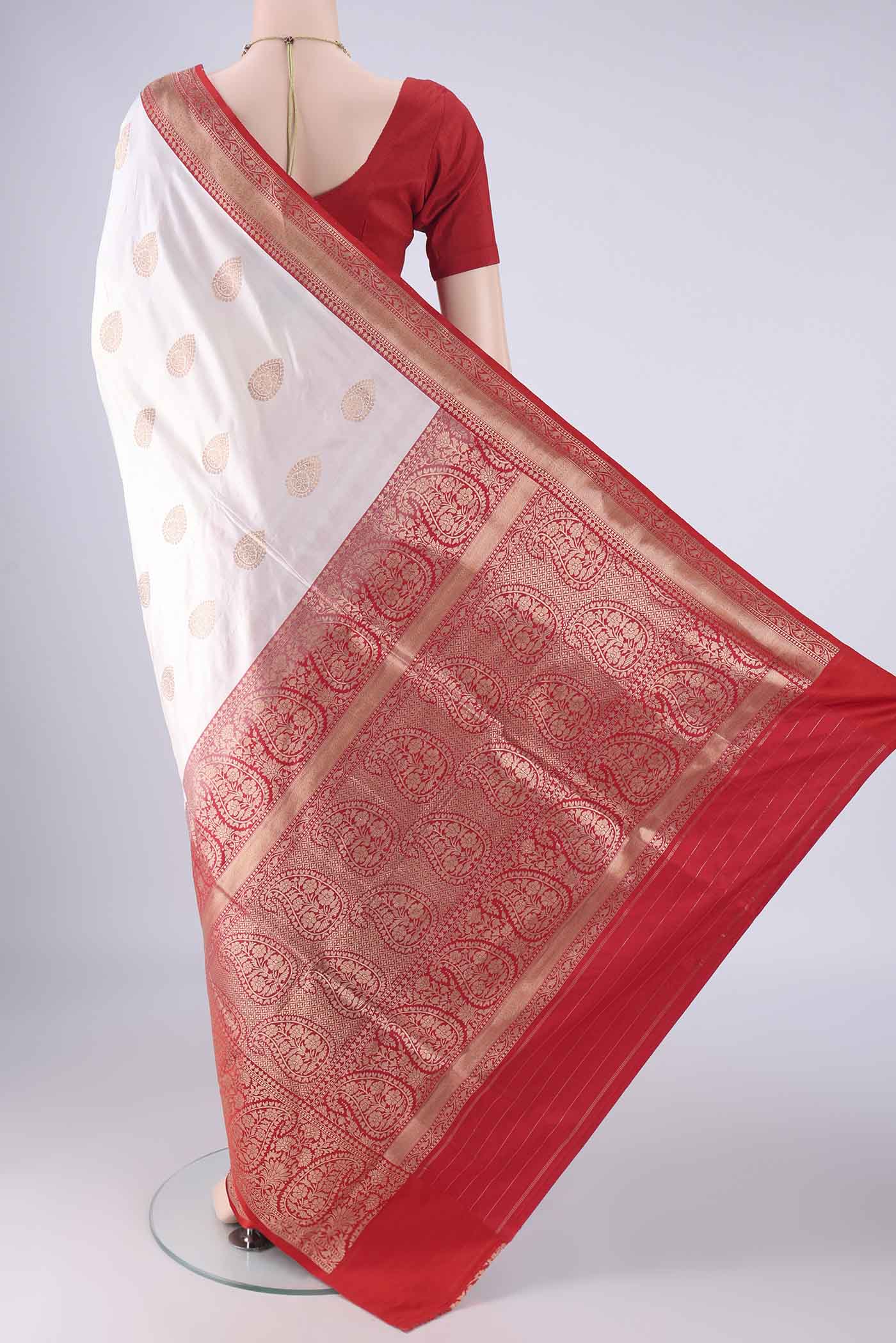 Flat view of White Banarasi Silk Saree with Zari Butta on the body and Zari Border. 