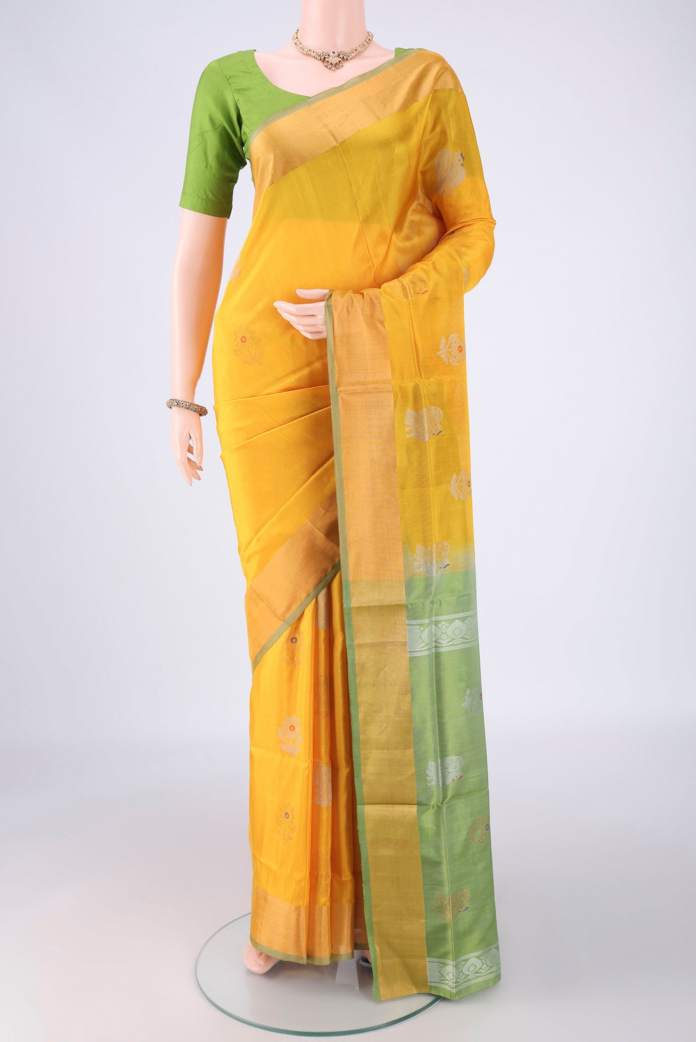 Yellow Uppada Silk Saree with Zari Butta on the body and Zari Border.  displayed on a mannequin