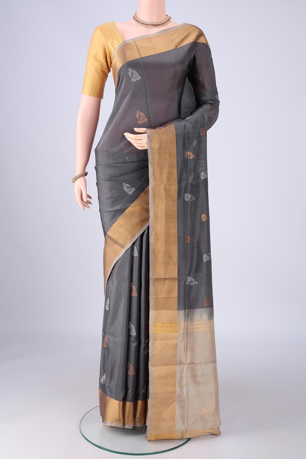 Grey Uppada Silk Saree with Zari And Thread Butta on the body and Zari Border.  displayed on a mannequin