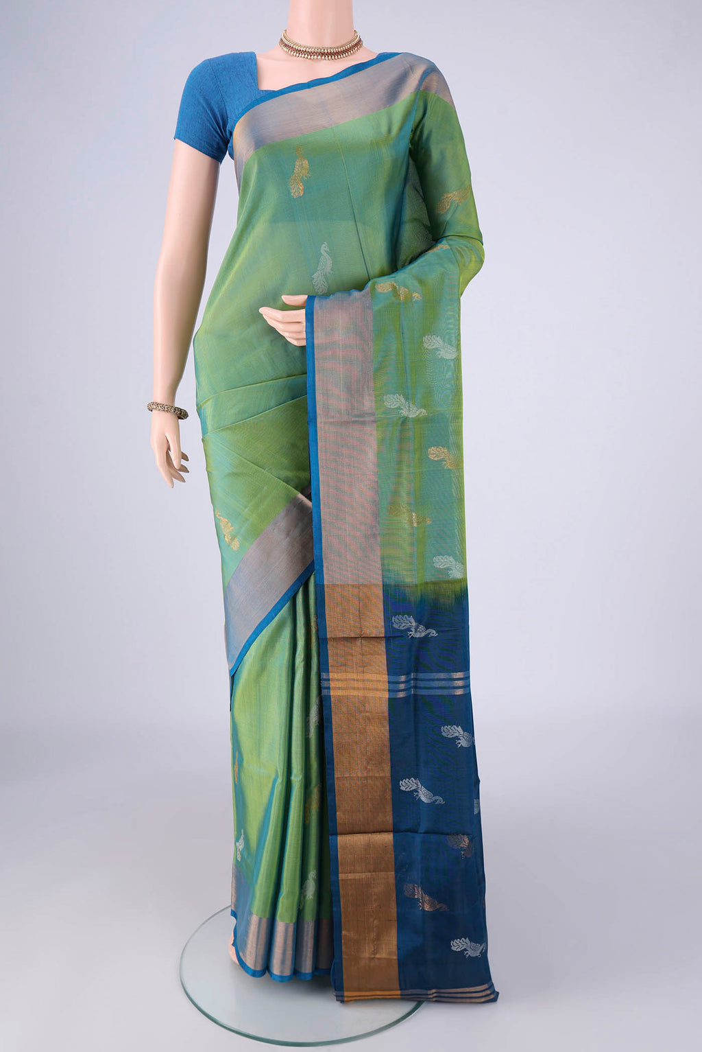 Light Green Uppada Silk Saree with Zari And Thread Butta on the body and Zari Border.  displayed on a mannequin