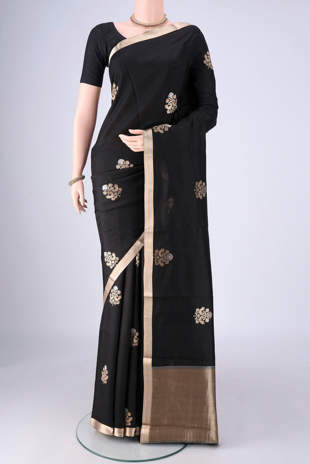 Black Banarasi Silk Saree with Zari Butta on the body and Zari Border.  displayed on a mannequin