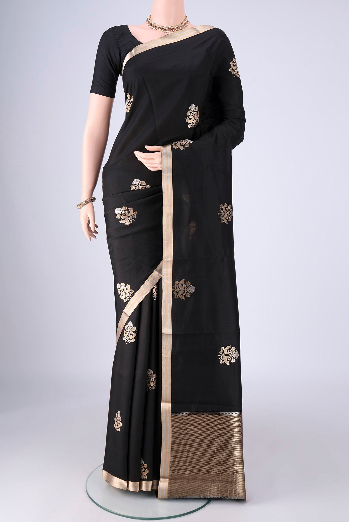 Black Banarasi Silk Saree with Zari Butta on the body and Zari Border.  displayed on a mannequin