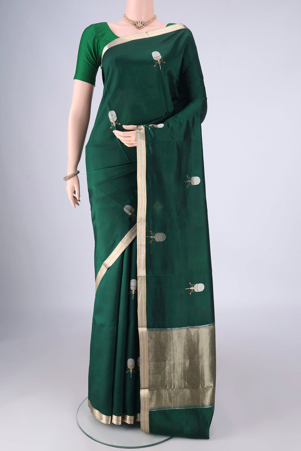 Bottle Green Banarasi Silk Saree with Zari Butta on the body and Zari Border.  displayed on a mannequin