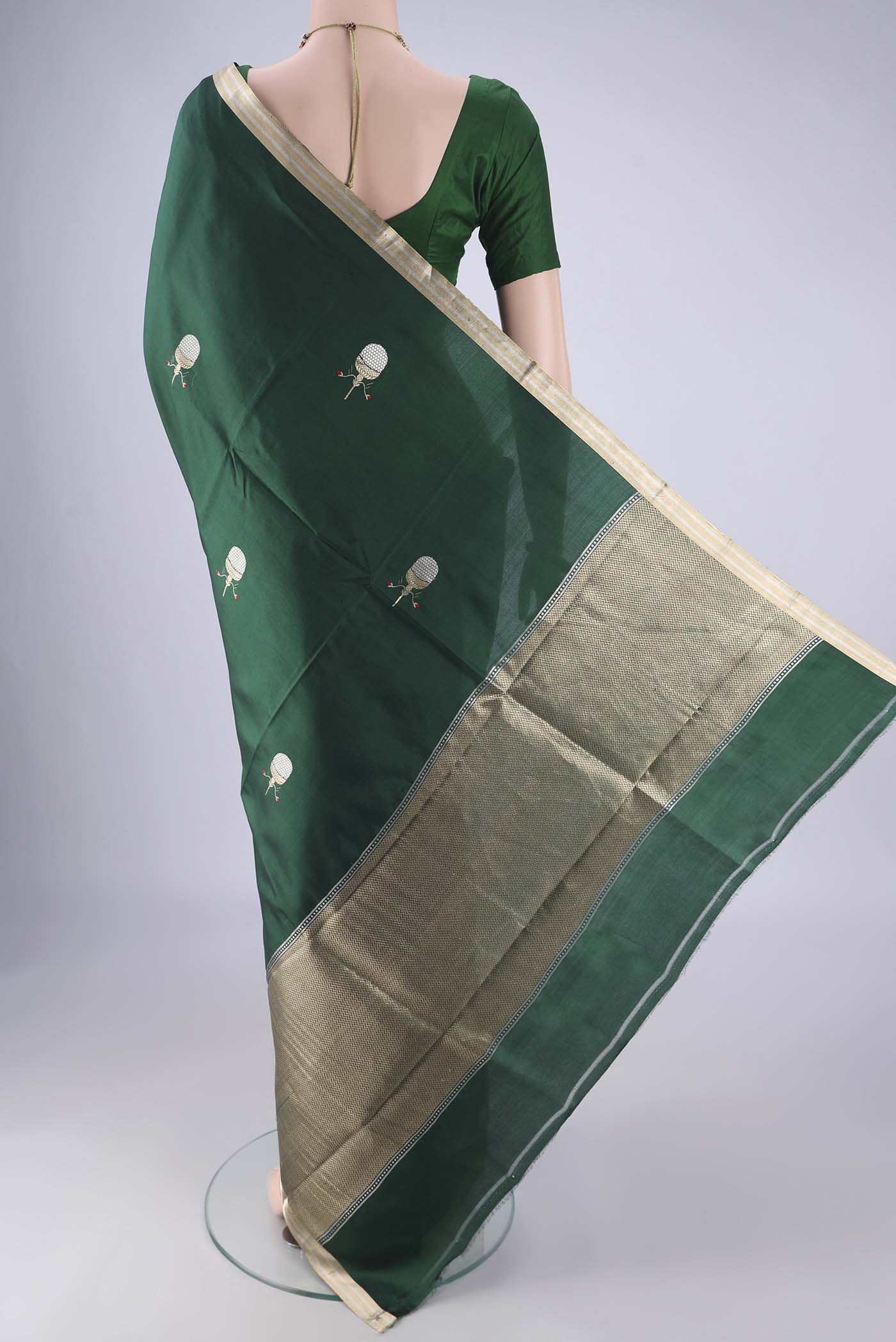 Flat view of Bottle Green Banarasi Silk Saree with Zari Butta on the body and Zari Border. 