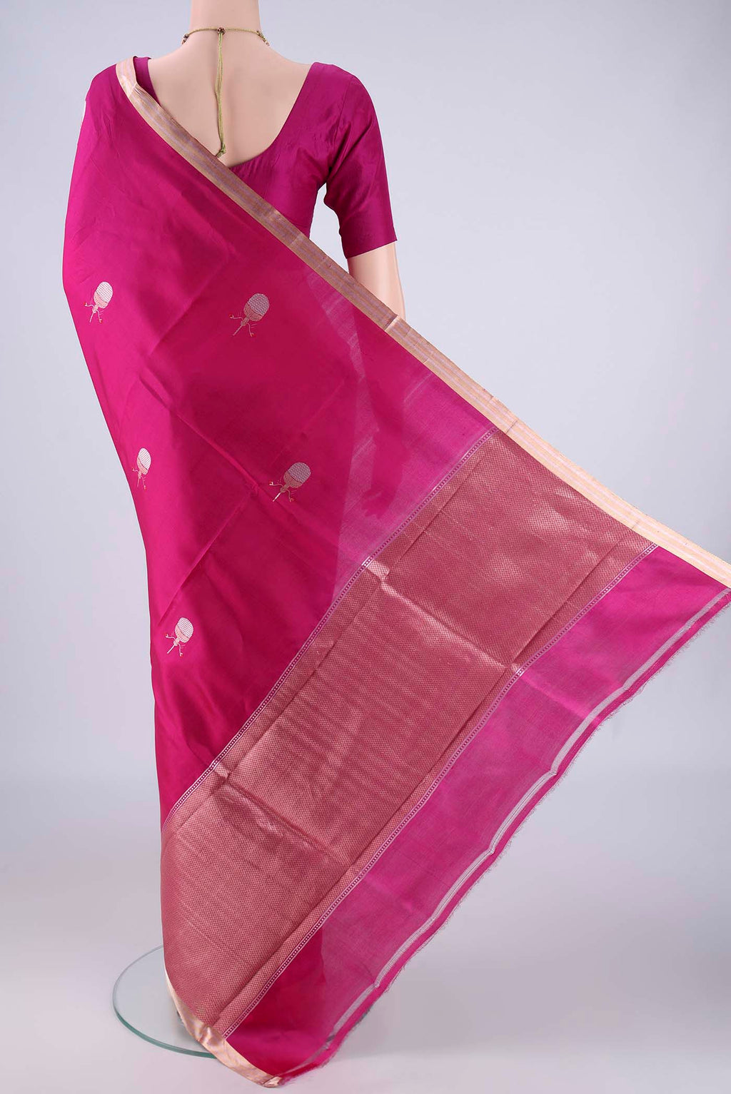 Flat view of Rani Pink Banarasi Silk Saree with Zari And Thread Butta on the body and Zari Border. 