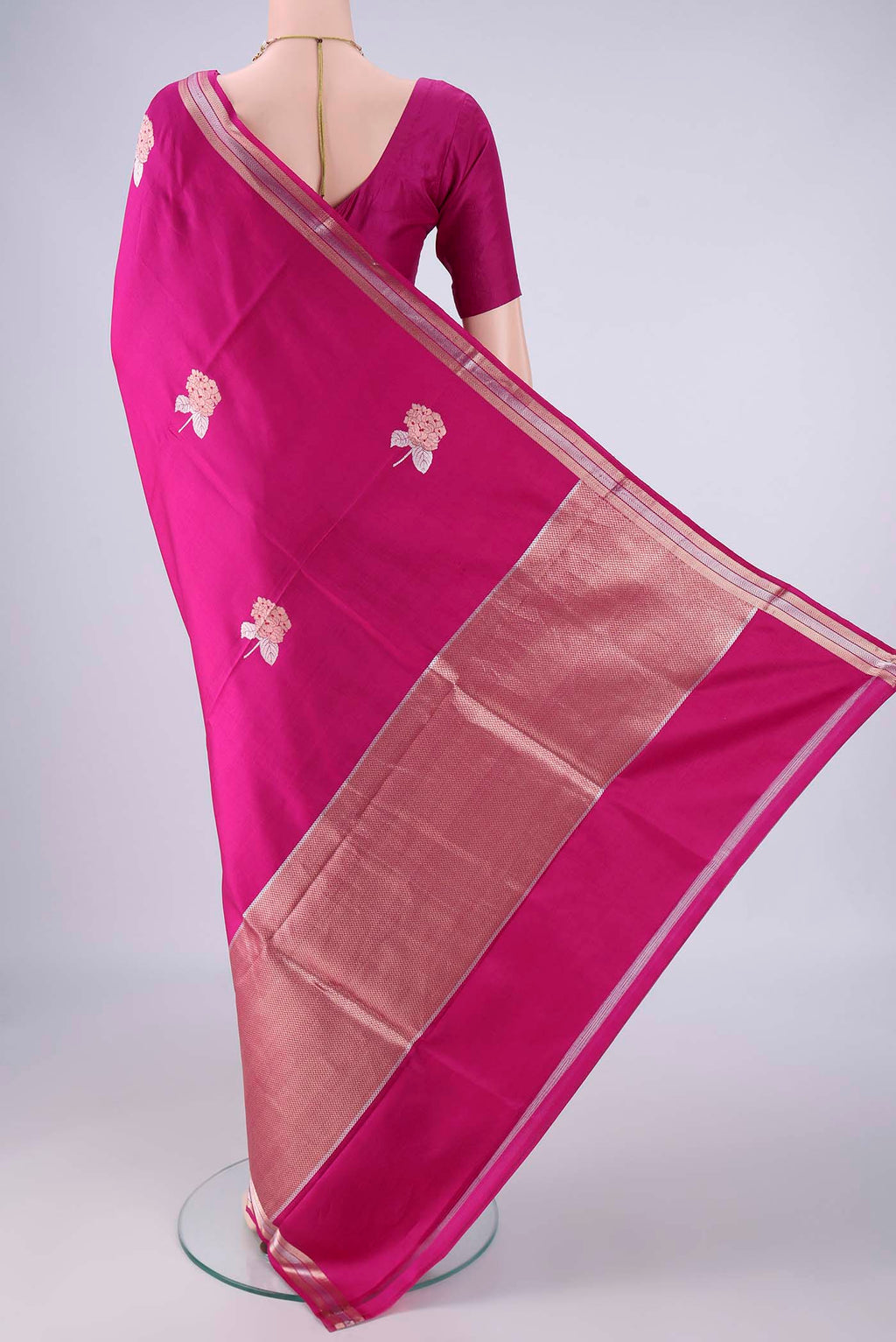 Flat view of Rani Pink Banarasi Silk Saree with Zari And Thread Butta on the body and Zari Border. 