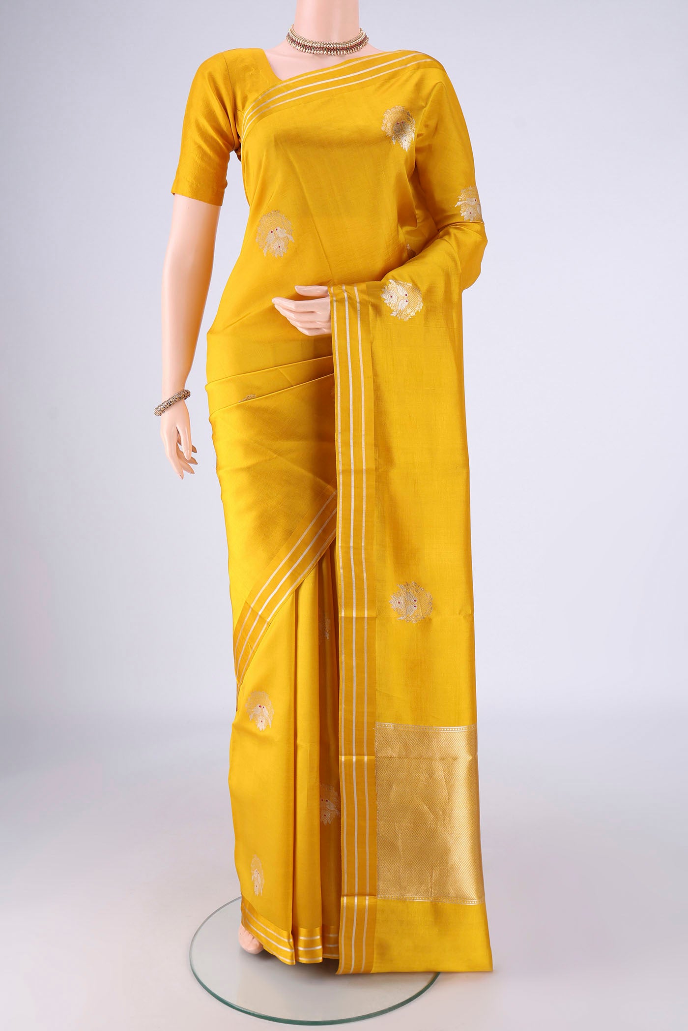 Yellow Banarasi Silk Saree with Zari Butta on the body and Zari Border.  displayed on a mannequin