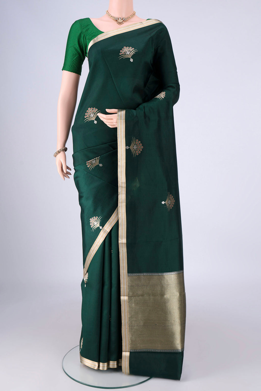 Bottle Green Banarasi Silk Saree with Zari Butta on the body and Zari Border.  displayed on a mannequin