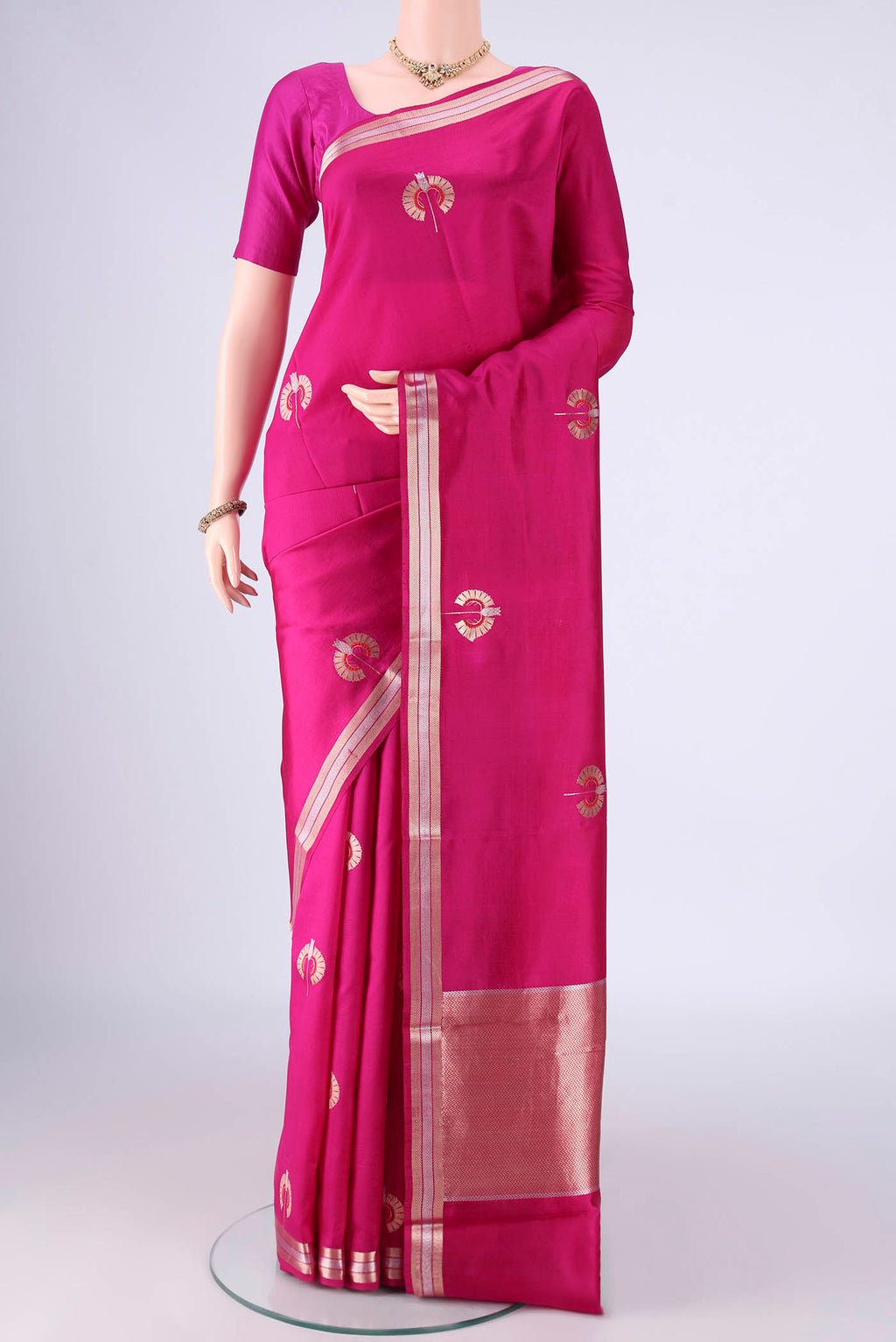 Rani Pink Banarasi Silk Saree with Zari And Thread Butta on the body and Zari Border.  displayed on a mannequin