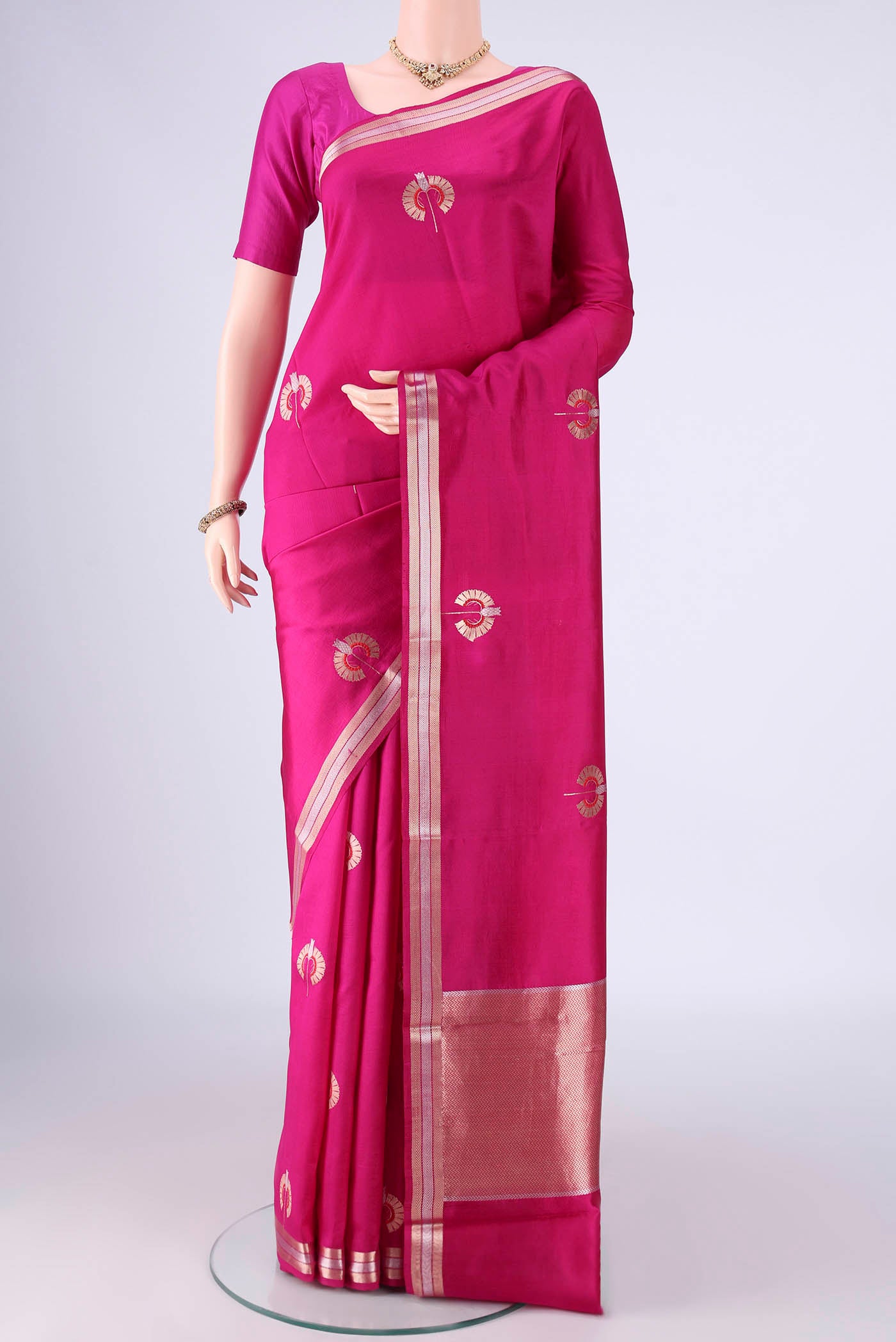 Rani Pink Banarasi Silk Saree with Zari And Thread Butta on the body and Zari Border.  displayed on a mannequin