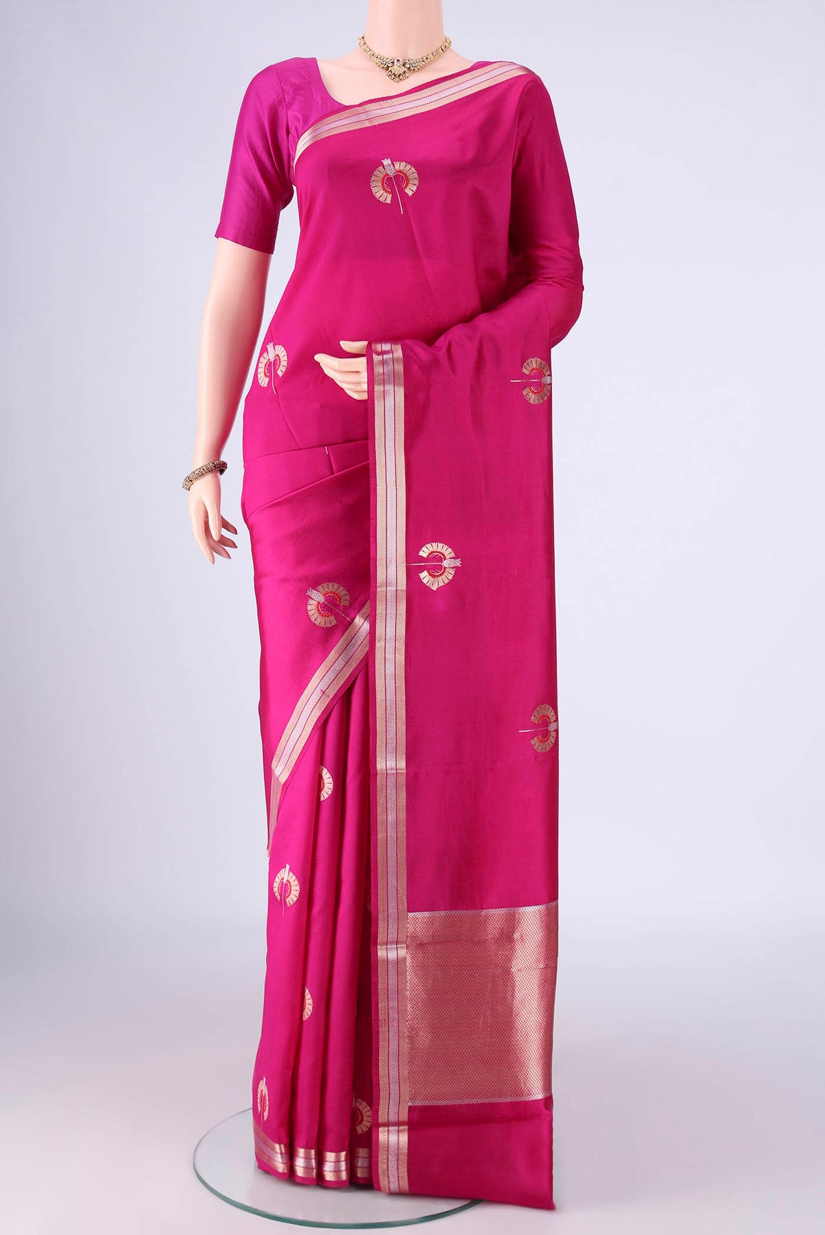Rani Pink Banarasi Silk Saree with Zari And Thread Butta on the body and Zari Border.  displayed on a mannequin
