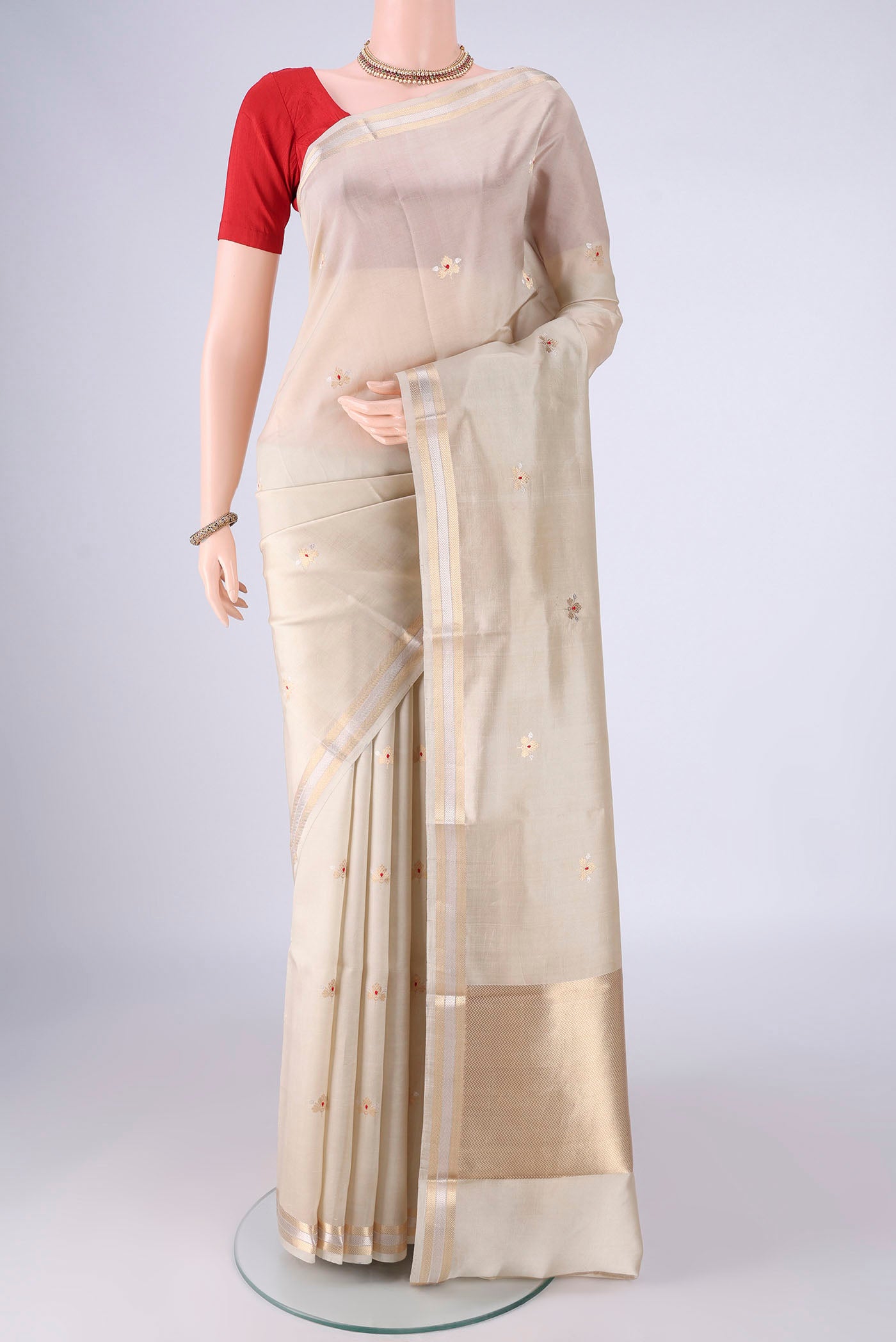 Beige Banarasi Silk Saree with Zari Butta on the body and Zari Border.  displayed on a mannequin