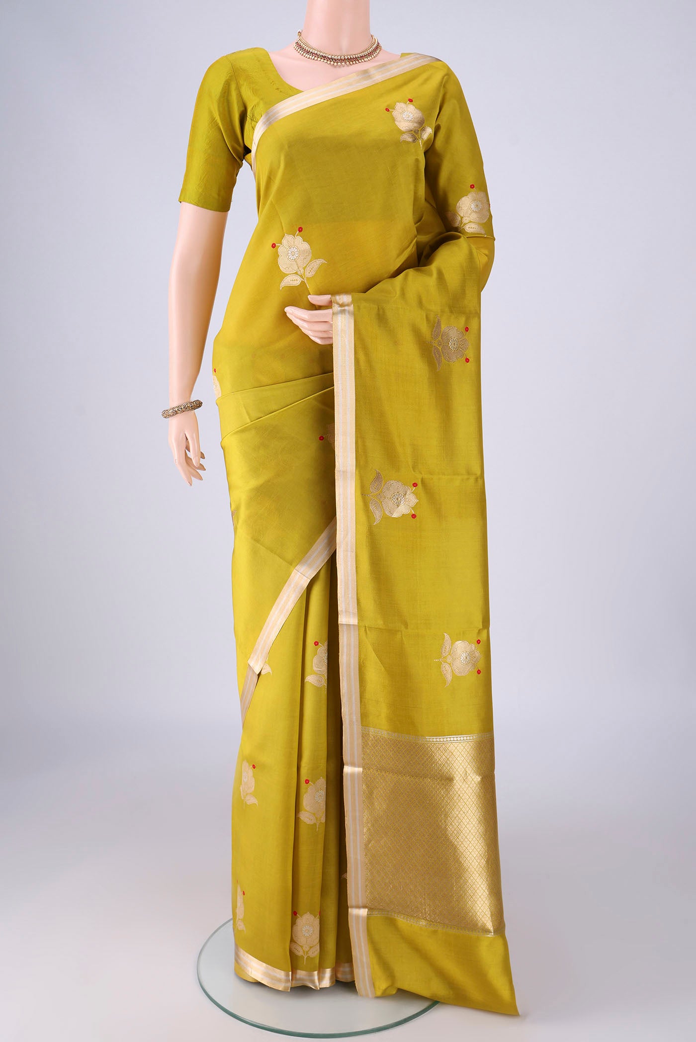 Mehandi Green Banarasi Silk Saree with Zari Butta on the body and Zari Border.  displayed on a mannequin
