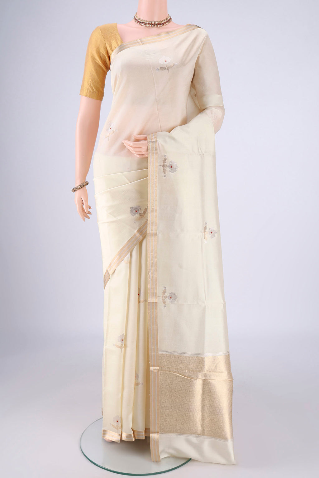 Cream Banarasi Silk Saree with Zari Butta on the body and Zari Border.  displayed on a mannequin