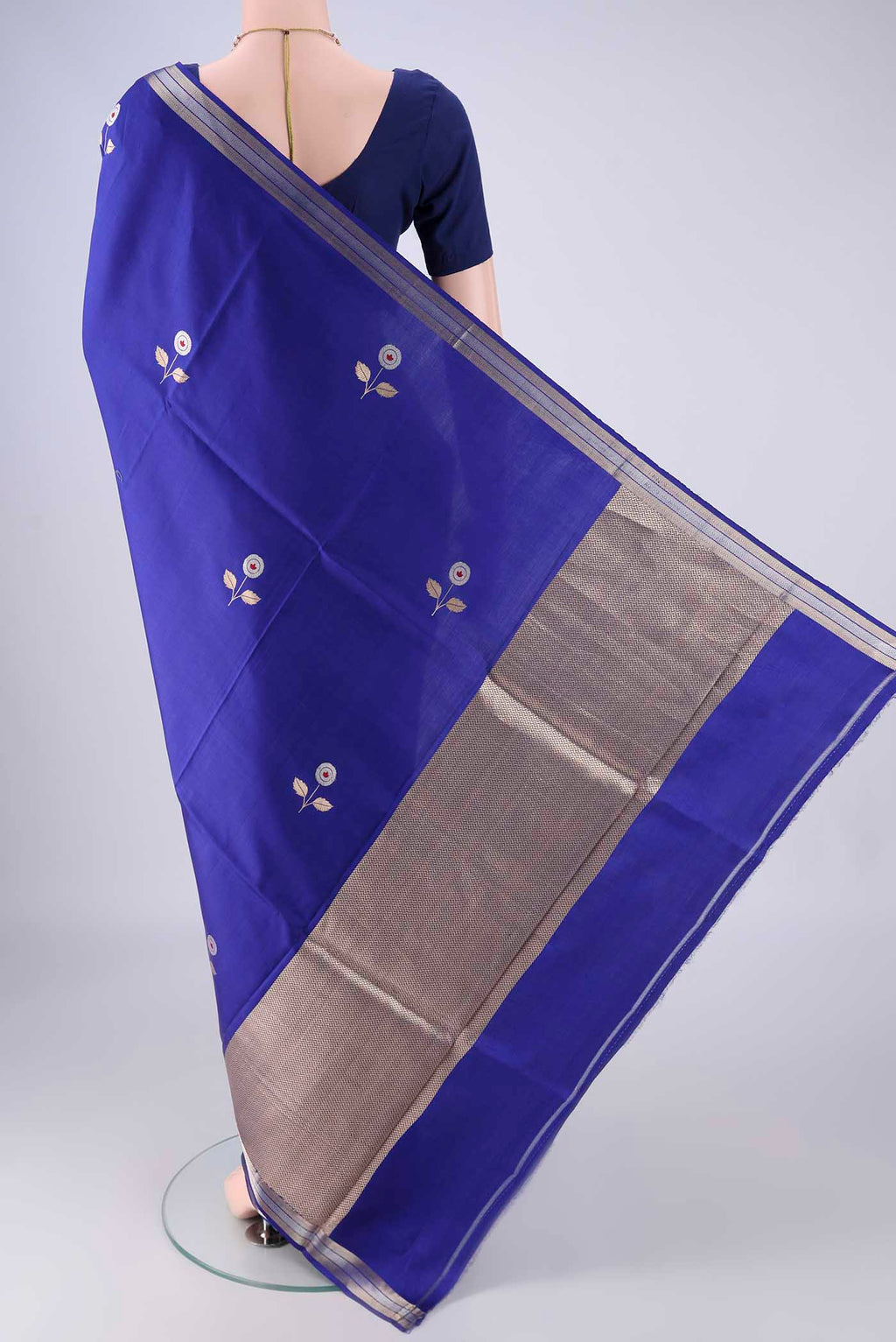 Flat view of Royal Blue Banarasi Silk Saree with Zari And Thread Butta on the body and Zari Border. 