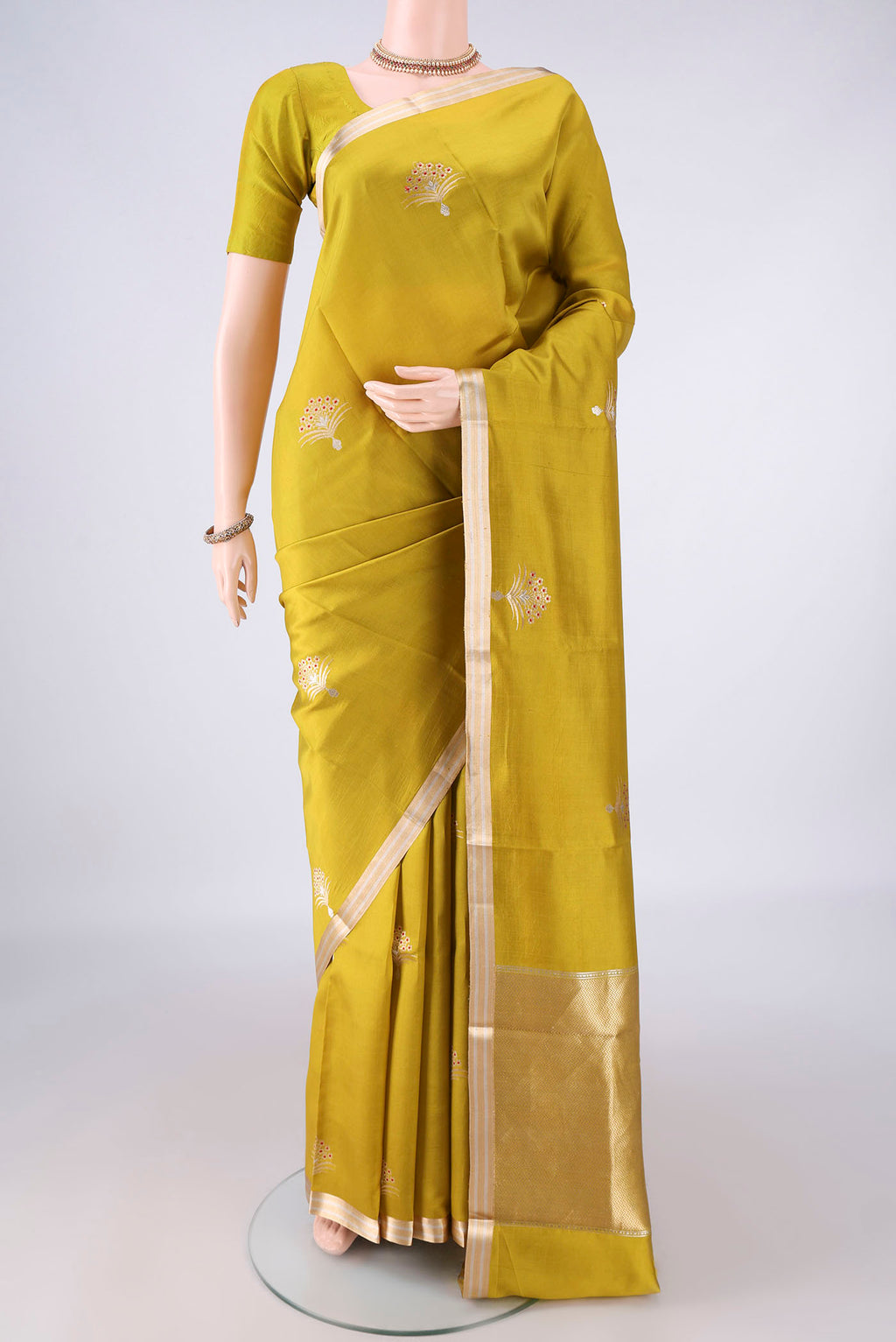 Pure Silk Mehandi Green Banarasi Saree with Zari Butta on the body and Zari Border.  displayed on a mannequin