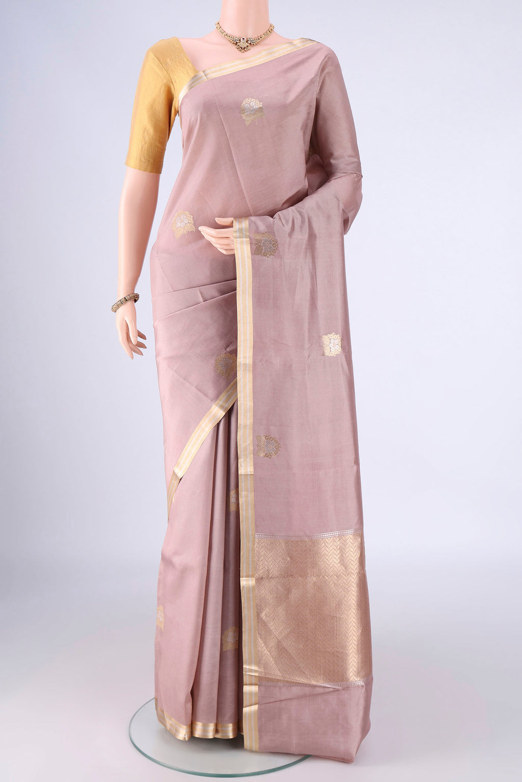 Rose Gold Banarasi Silk Saree with Zari Butta on the body and Zari Border.  displayed on a mannequin