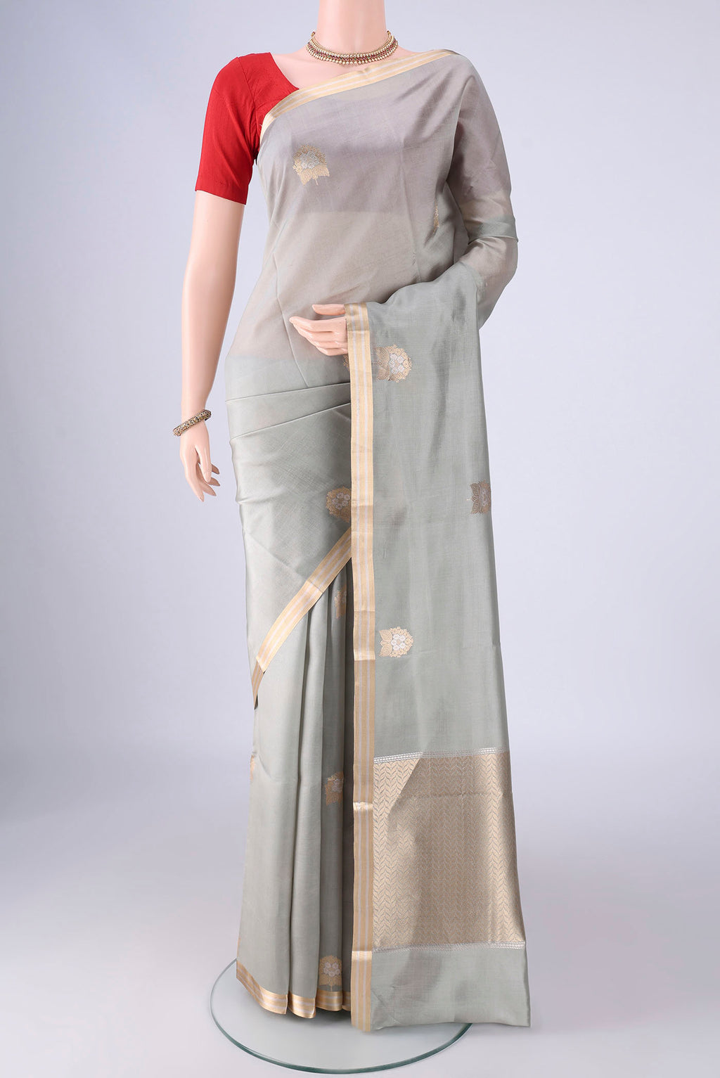 Grey Banarasi Silk Saree with Zari Butta on the body and Zari Border.  displayed on a mannequin