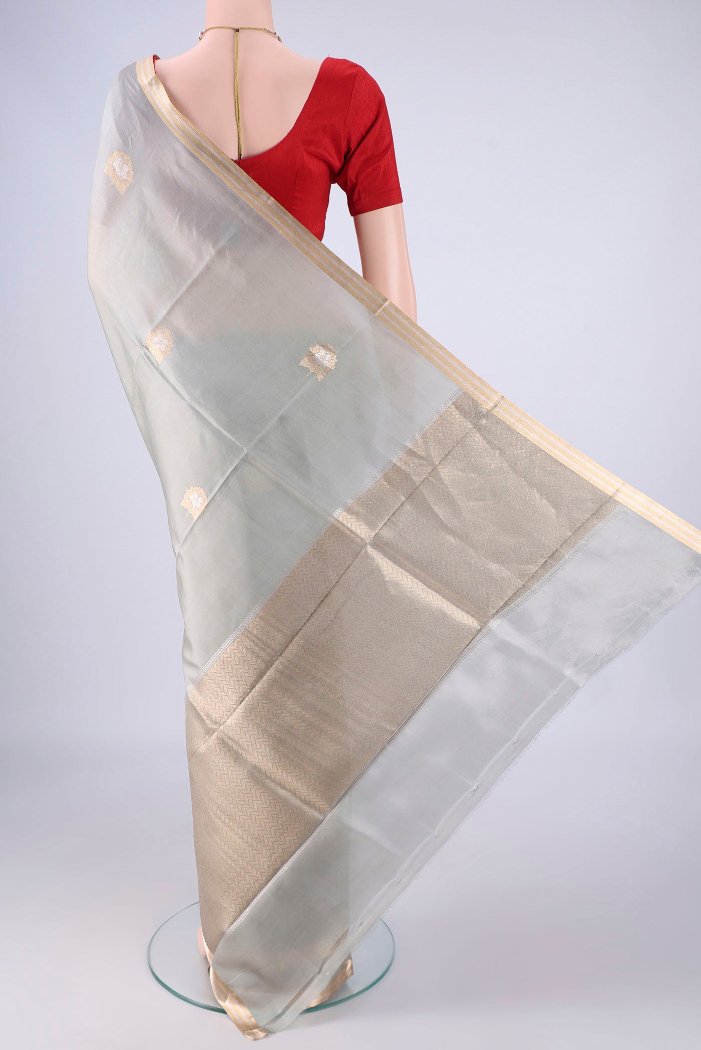 Flat view of Grey Banarasi Silk Saree with Zari Butta on the body and Zari Border. 