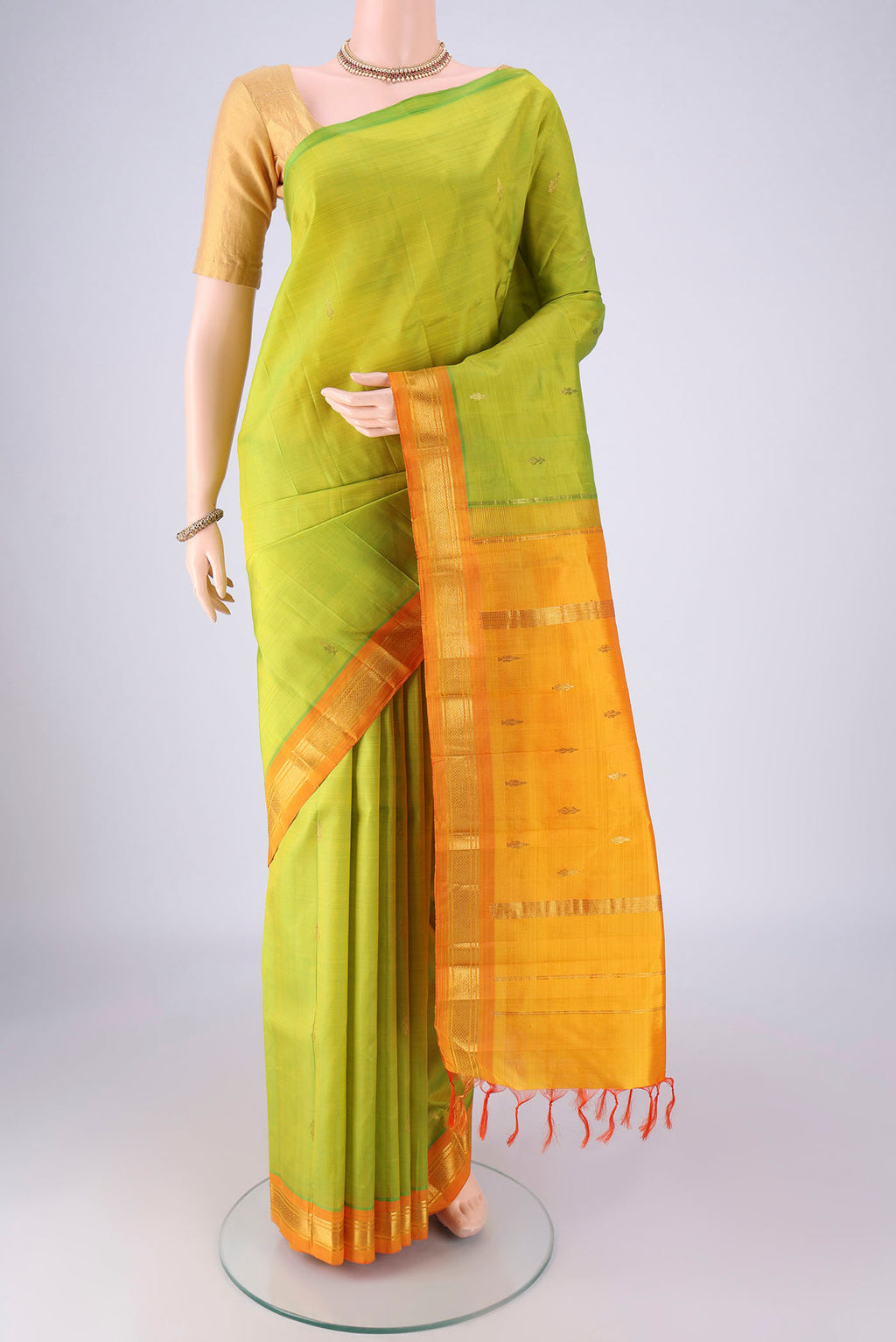 Green Kanchipuram Silk Saree with Zari Butta on the body and One Side Border.  displayed on a mannequin