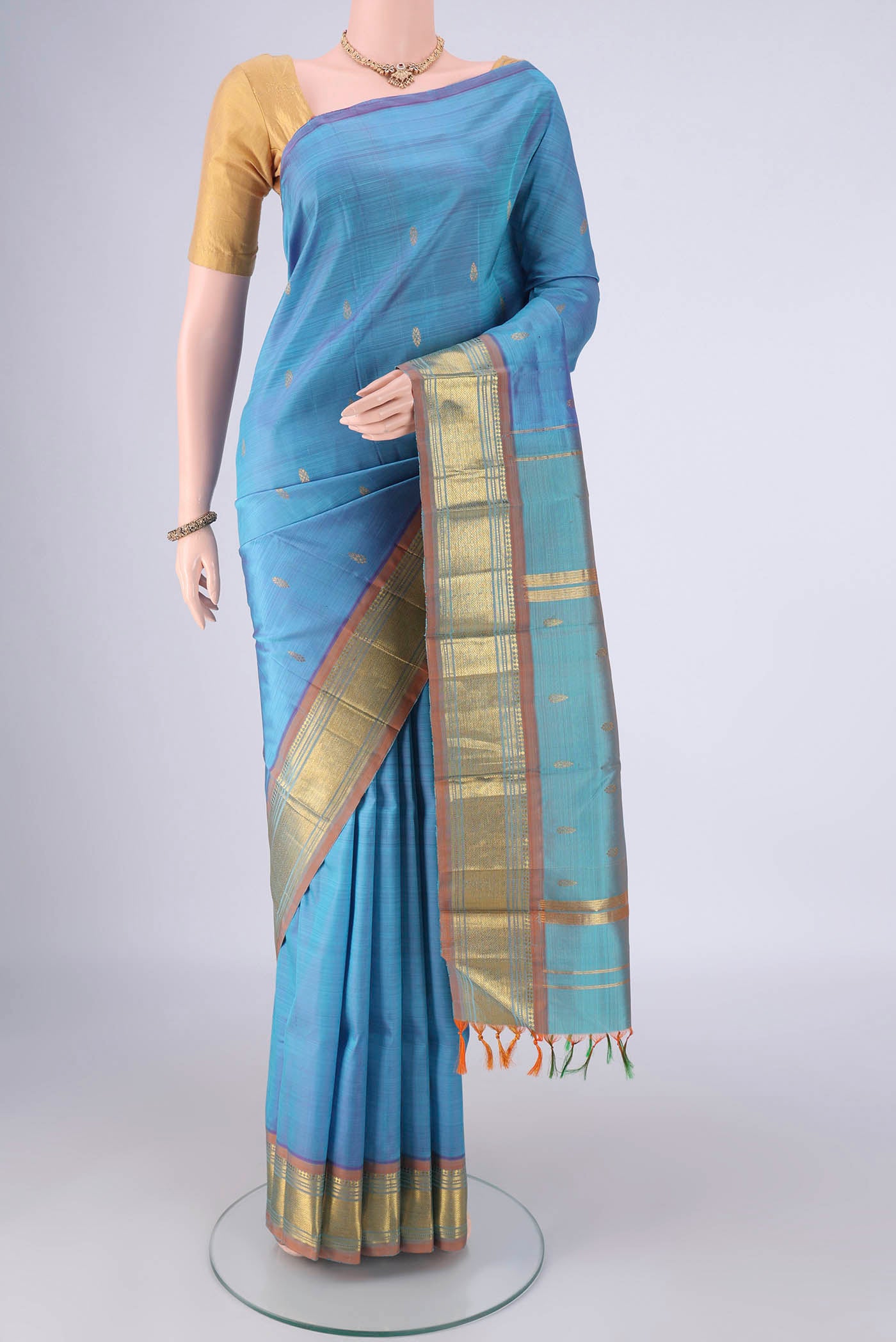 Sky Blue Kanjivaram Silk Saree with Zari Butta on the body and One Side Border.  displayed on a mannequin