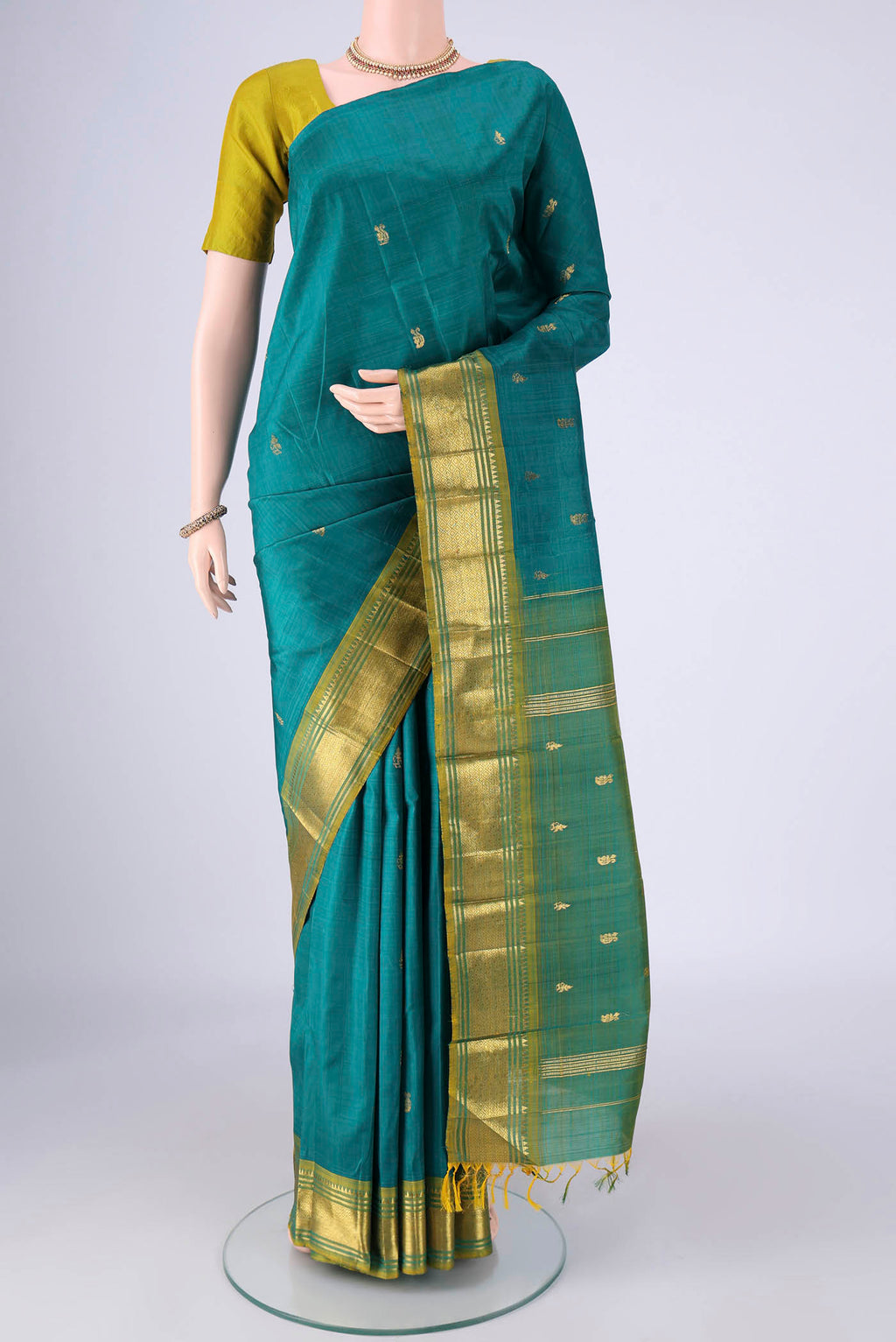 Peacock Blue Kanjivaram Silk Saree with Zari Butta on the body and One Side Border.  displayed on a mannequin