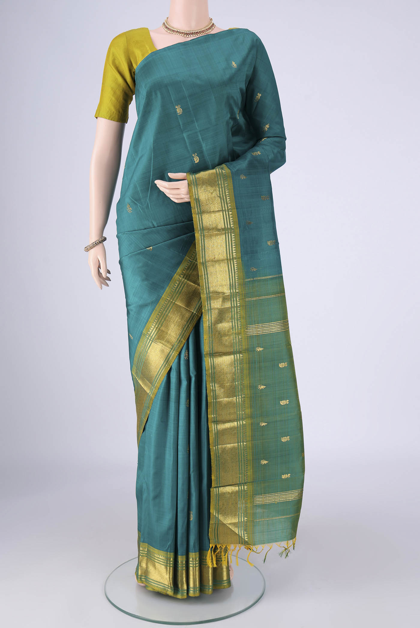 Peacock Blue Kanjivaram Silk Saree with Zari Butta on the body and One Side Border.  displayed on a mannequin