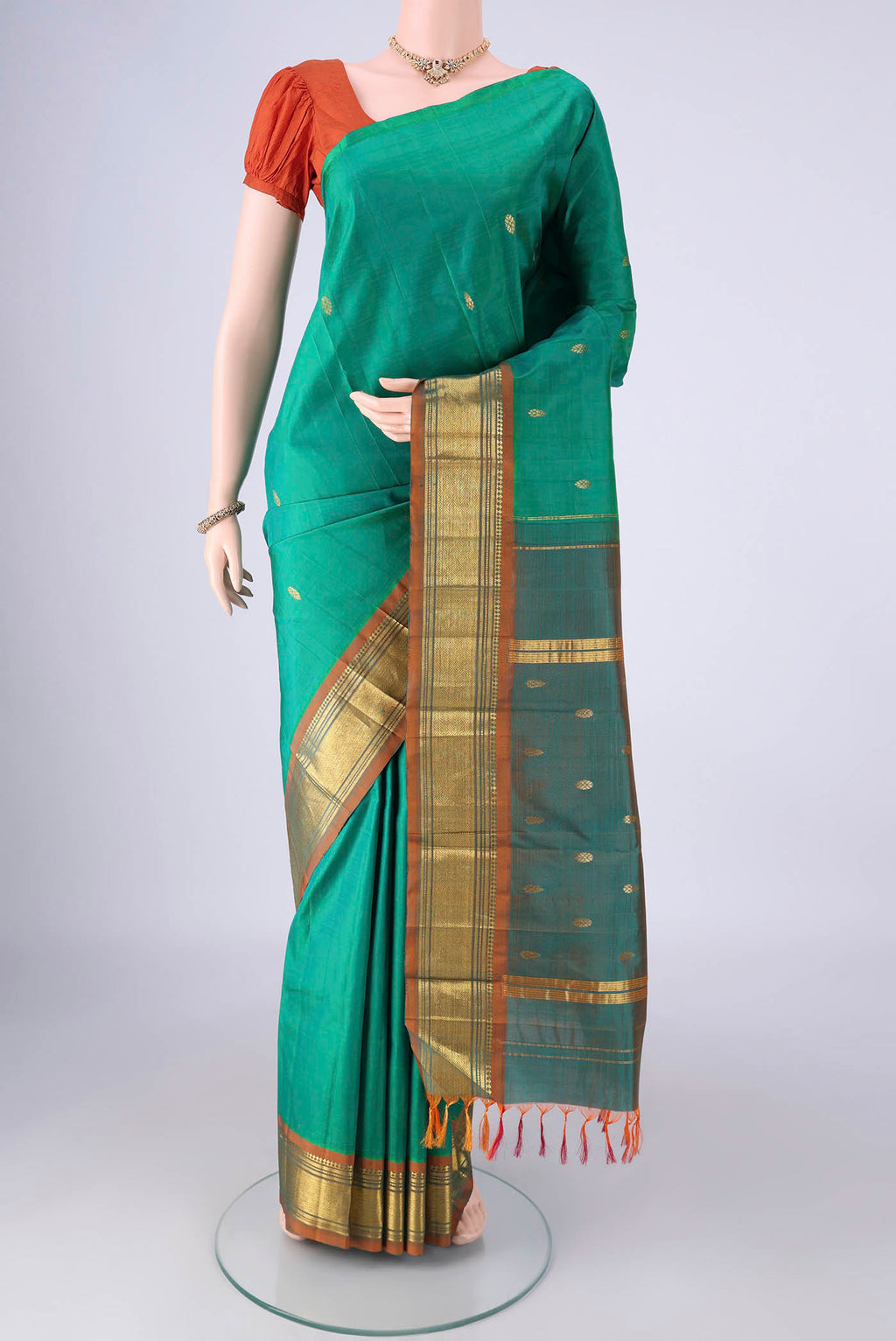 Sea Green Kanjivaram Silk Saree with Zari Butta on the body and One Side Border.  displayed on a mannequin