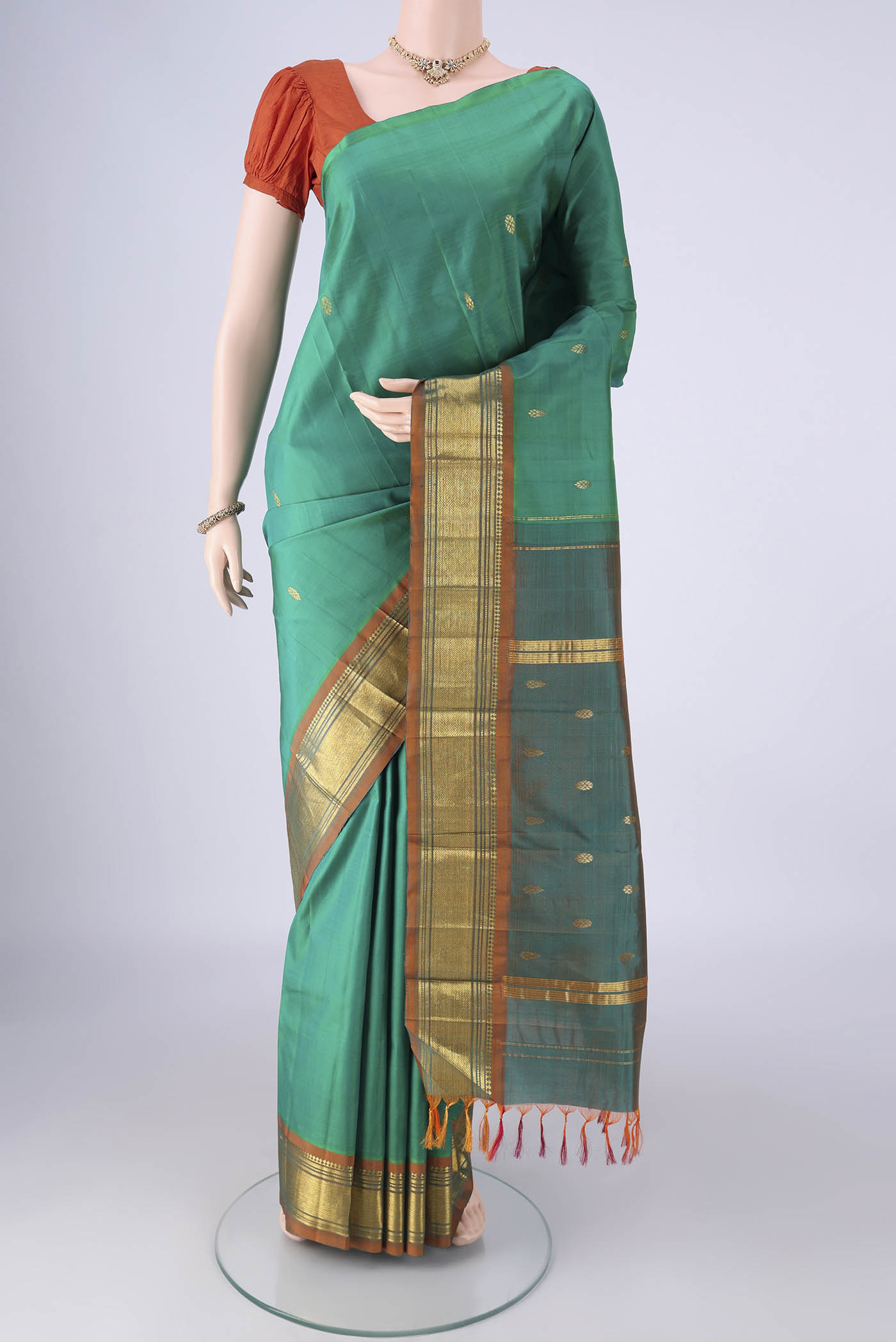 Sea Green Kanjivaram Silk Saree with Zari Butta on the body and One Side Border.  displayed on a mannequin