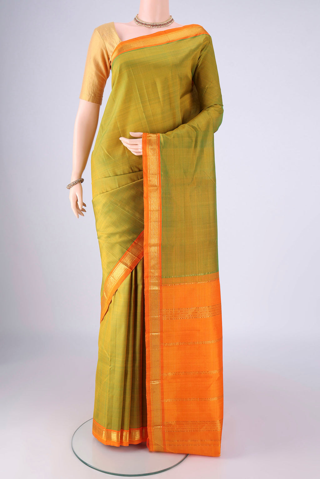 Light Green Kanjivaram Silk Saree with Plain Body and Zari Border.  displayed on a mannequin