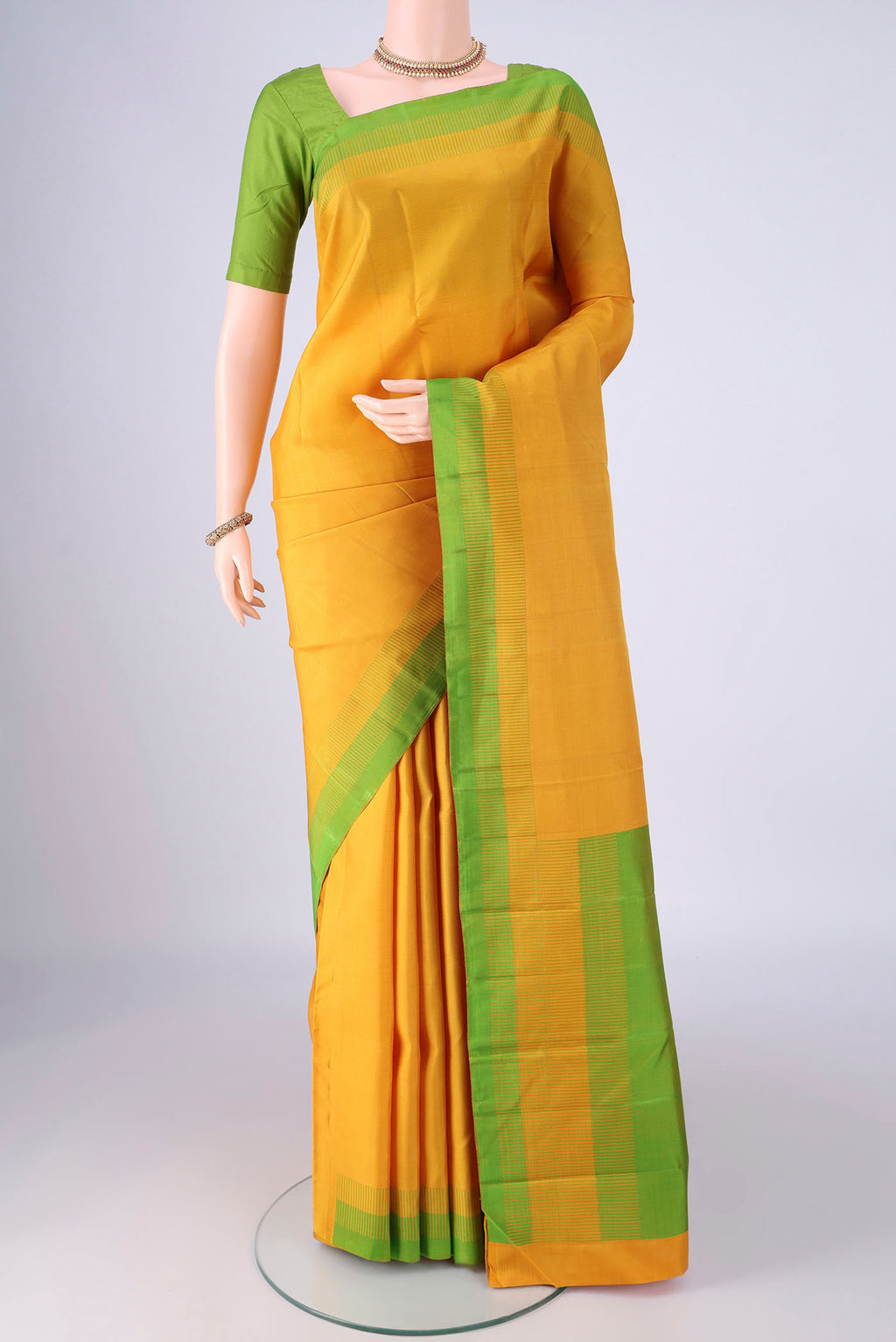 Yellow Kanjivaram Silk Saree with Plain Body and Thread Border.  displayed on a mannequin