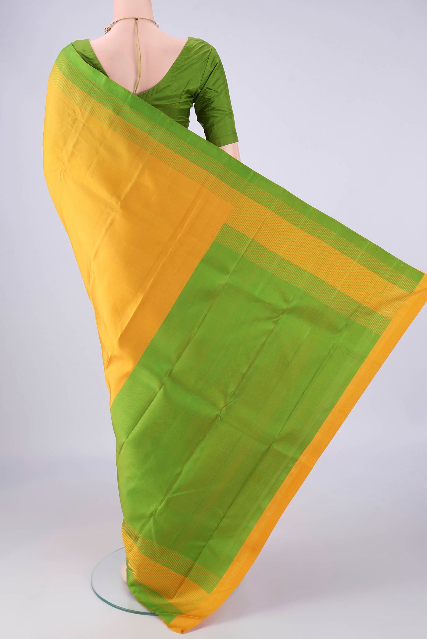 Flat view of Yellow Kanjivaram Silk Saree with Plain Body and Thread Border. 