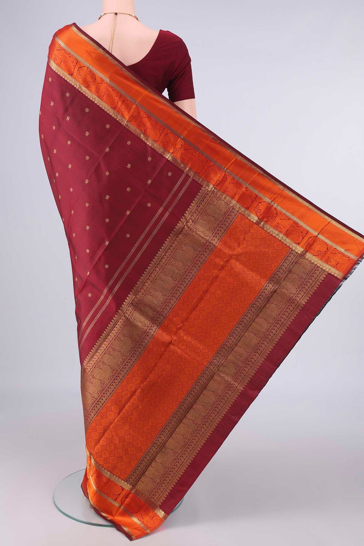 Flat view of Pure Silk Pure Zari Maroon Kanchipuram Saree with Zari Butta on the body and Zari And Thread Border. 