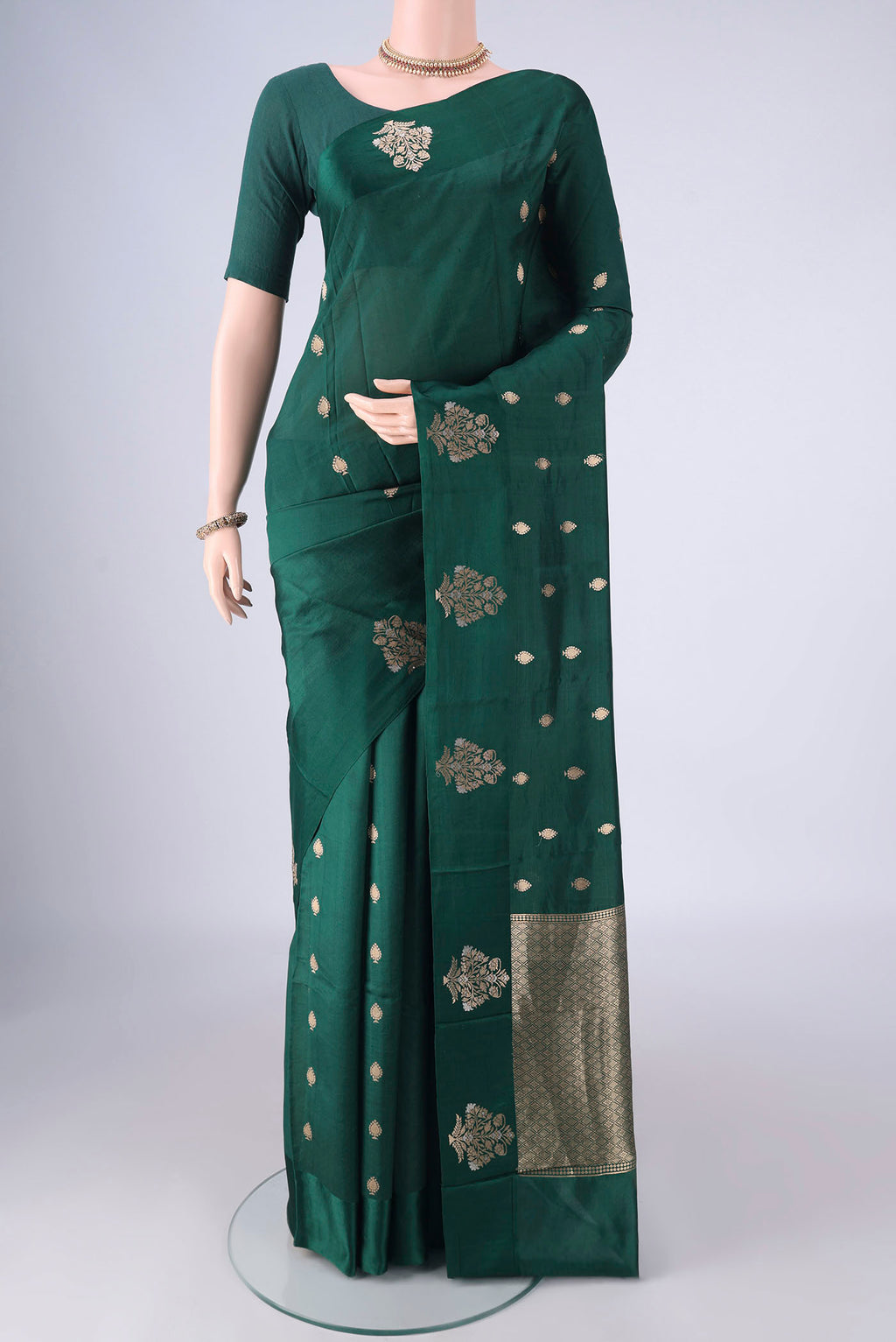 Bottle Green Banarasi Katan Silk Saree with Zari Butta on the body and Satin Border.  displayed on a mannequin
