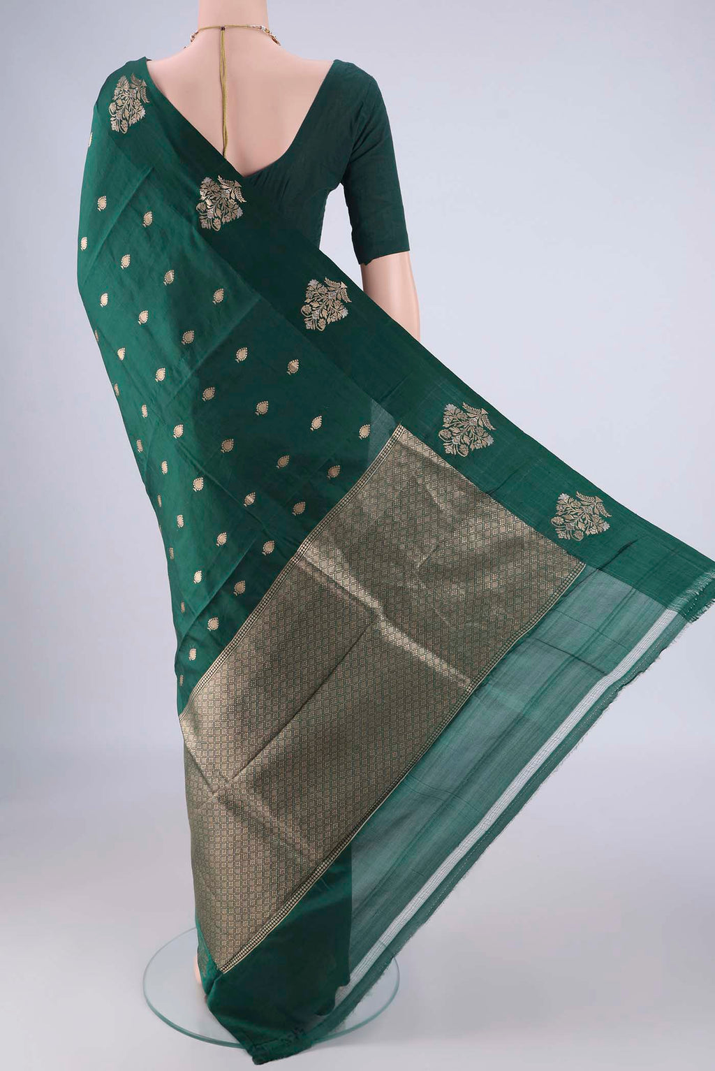 Flat view of Bottle Green Banarasi Katan Silk Saree with Zari Butta on the body and Satin Border. 