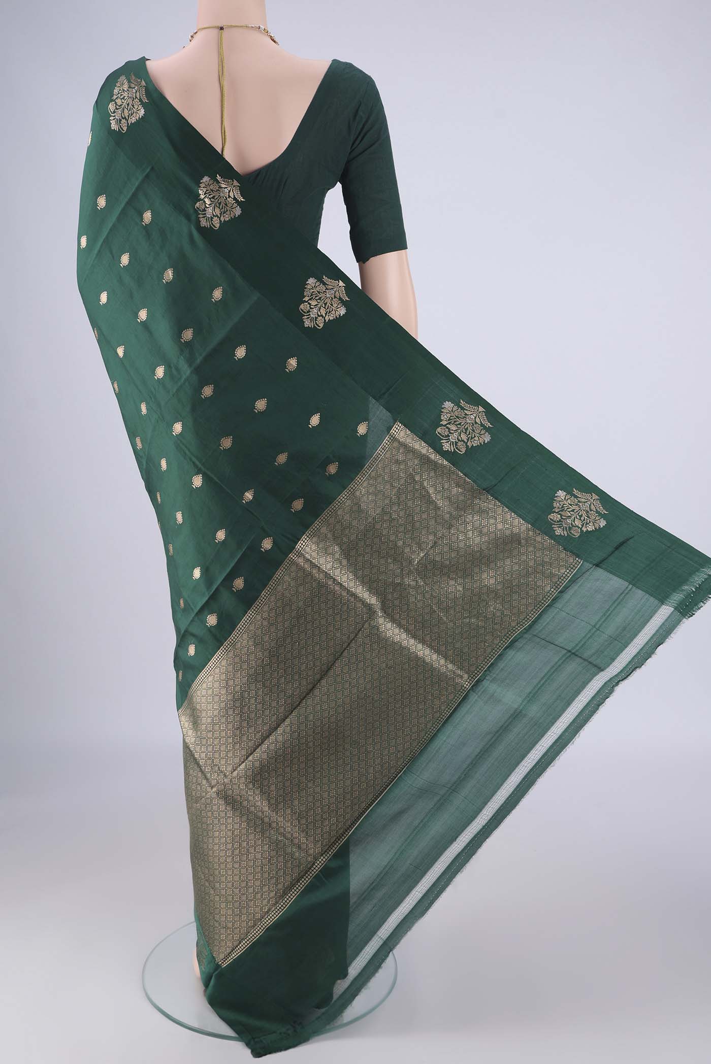 Flat view of Bottle Green Banarasi Katan Silk Saree with Zari Butta on the body and Satin Border. 