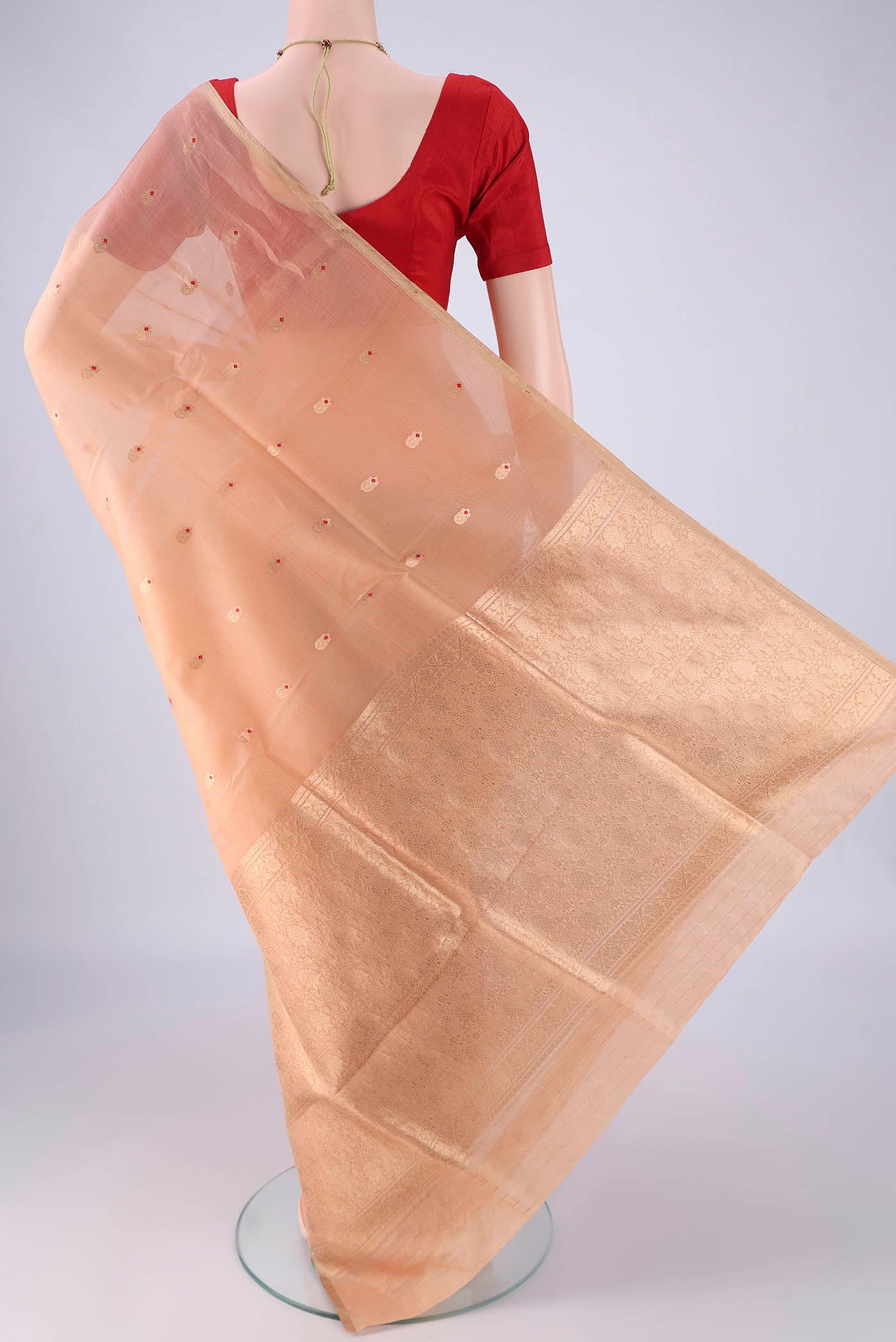 Flat view of Peach Organza Silk Saree with Zari And Thread Butta on the body and Thin Zari Line. 