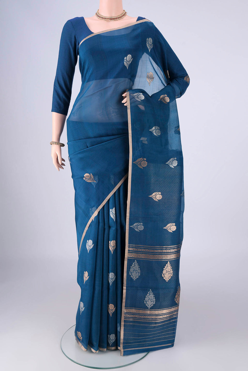 Blue Organza Silk Saree with Zari And Thread Butta on the body and Thin Zari Line.  displayed on a mannequin